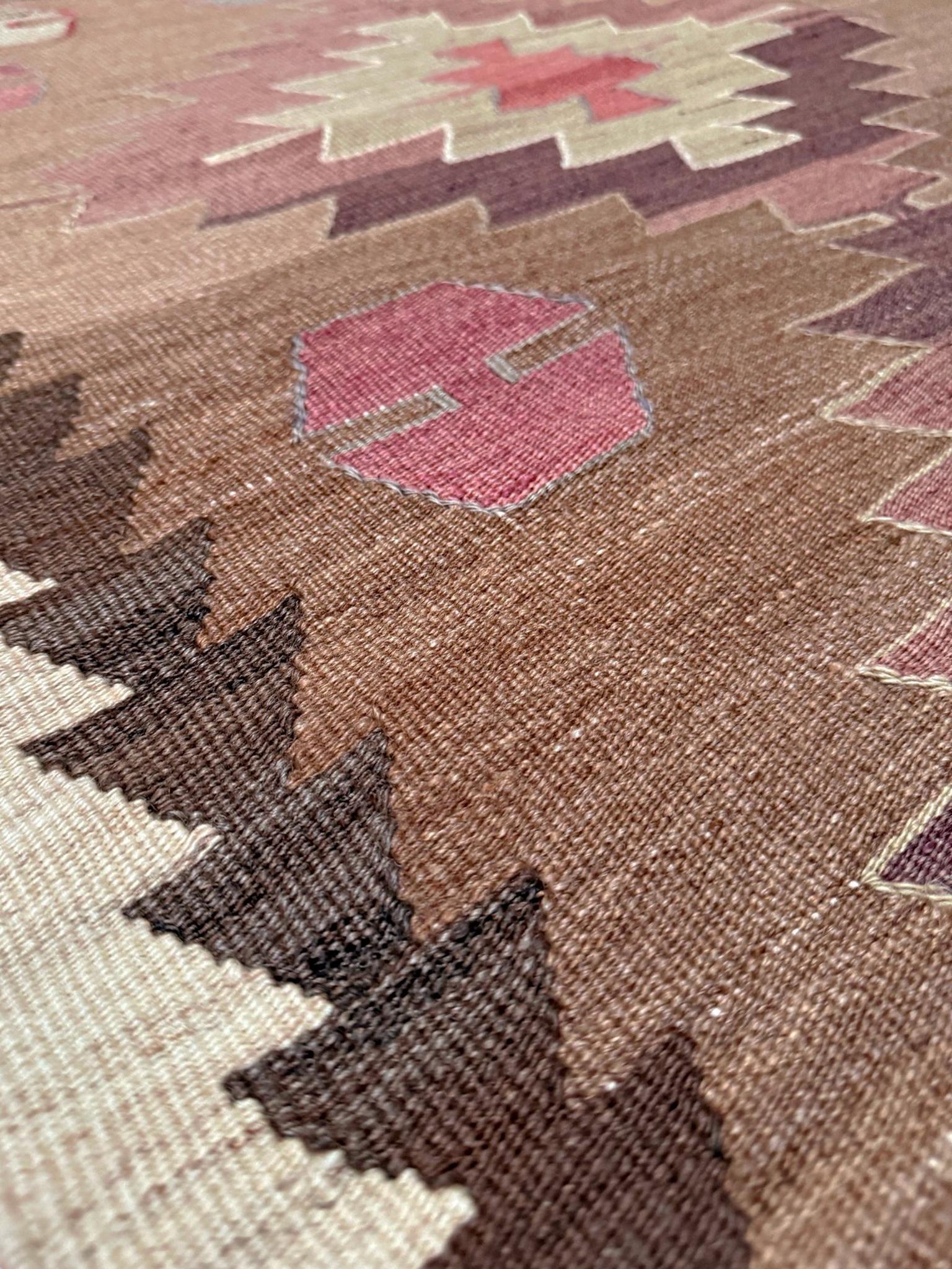 Un kilim Mut di metà secolo proveniente dalla Turchia meridionale, tessuto con un'audace disposizione a medaglioni a gradini che ricorda le tradizioni di tessitura Navajo. La catena di diamanti ripetuta crea una composizione pulita e ritmica,