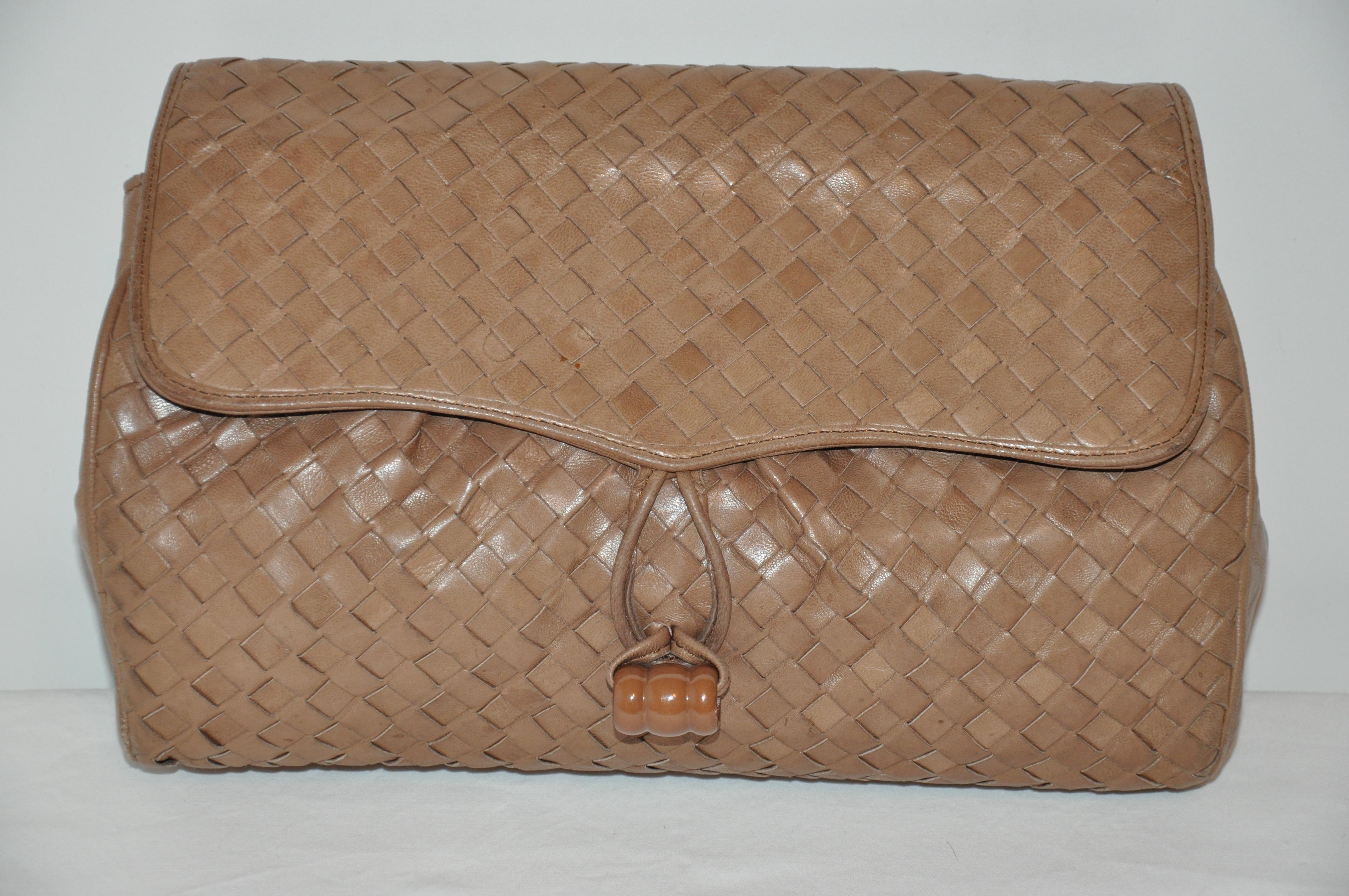      Wonderfully butter soft, this taupe woven lambskin optional clutch or shoulder bag has a taupe lucite 