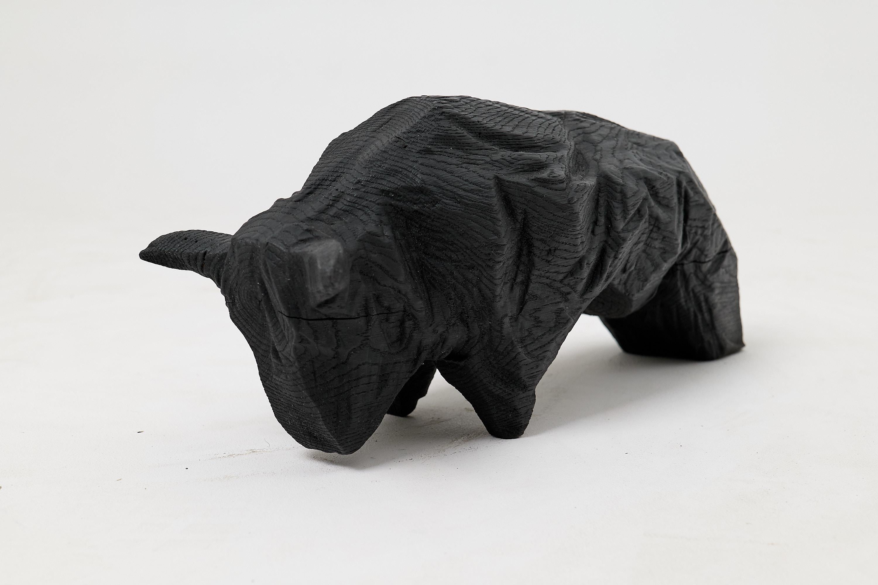 Questa imponente scultura di toro è un pezzo unico, scolpito a mano da un unico blocco di legno massiccio. La sua forma potente è ridotta a una serie di piani forti e sfaccettati, che catturano l'essenza dell'animale con una sensibilità minimalista