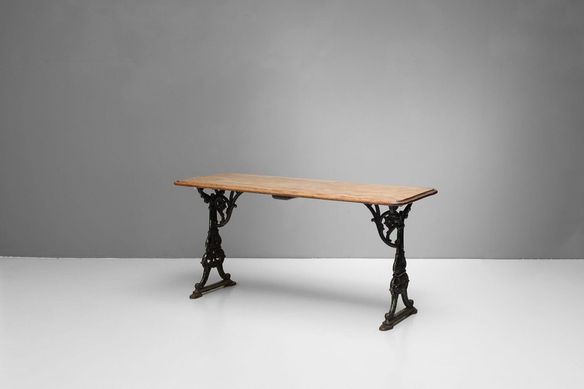 Tavolo da taverna con piano in mogano e terminali in ghisa. K.K. circa 1870.

H. 74cm x L. 153cm x P. 59cm
