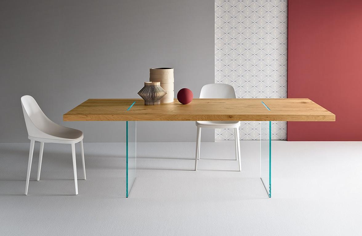 The table, conceived by designer Marco Gaudenzi, has a top made of reclaimed oak beams that are processed so as to highlight cracks and knots, components of wood’s natural aesthetic. 

The wood gives this table a solid appearance, while the glass