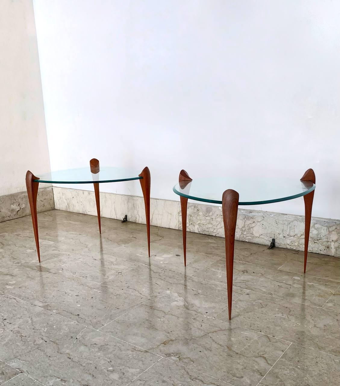 In the style of Max Ingrand coppia tavolini bassi  Fontana Arte, Italia, anni '1950-1960.
Con base in legno e piano in cristallo sagomato ad incastro.
La bellezza e la storia parlano da se.
In particolare possiamo notare la  documentazione