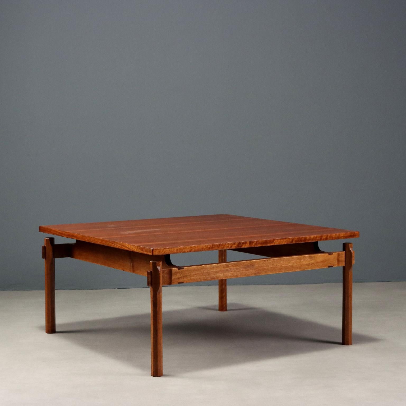 Table centrale vintage en bois de teck avec des pieds à section octogonale, sculptés pour permettre l'emboîtement des barres transversales, dont deux sont surélevées et soutiennent le plateau carré. Restauré dans nos ateliers. Très bon état.