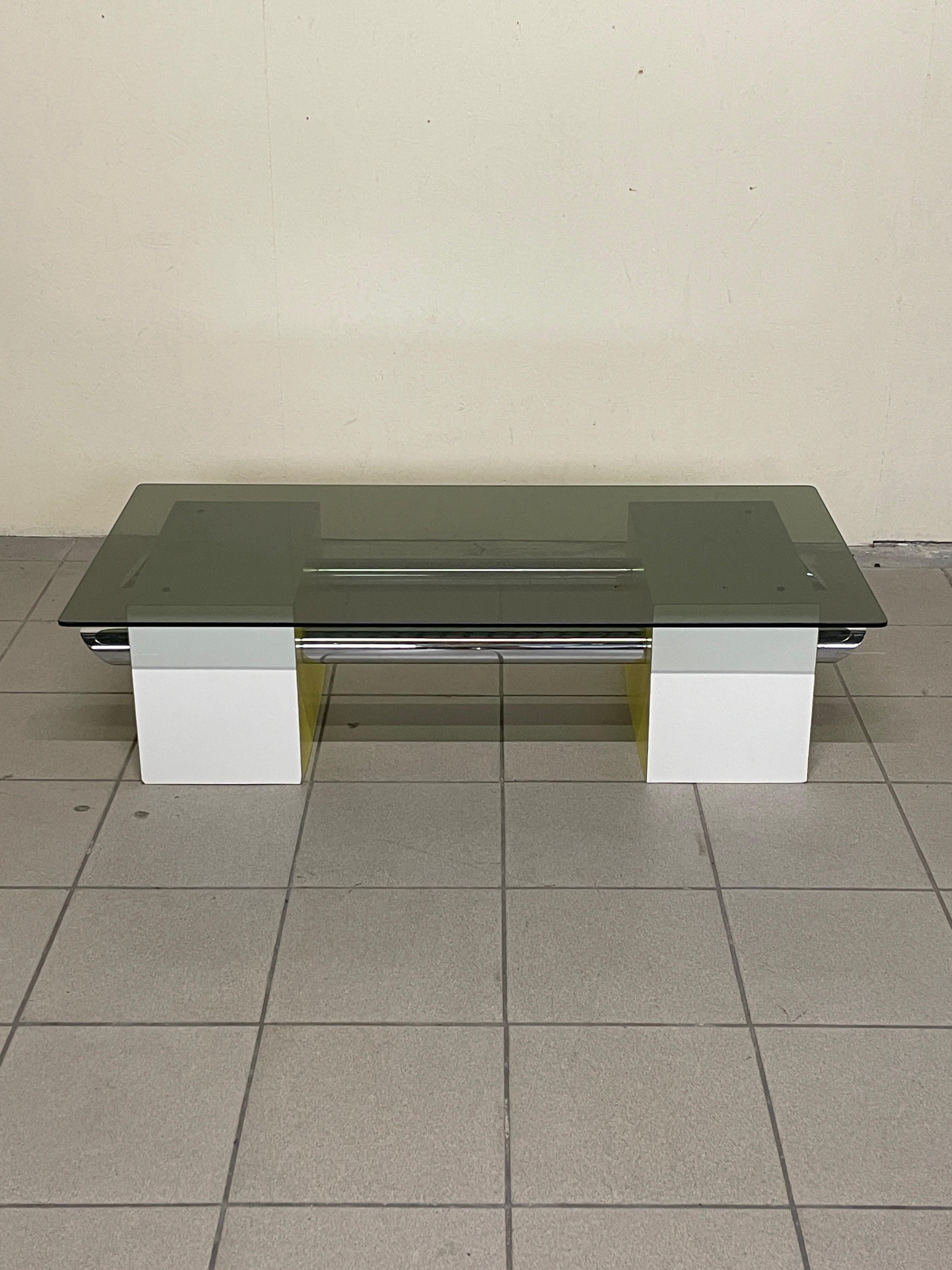 Tavolino da salotto in perfetto stile space-age.

Metallo cromato, formica colorata e un vetro fumé caratterizzano la sua struttura importante ma anche molto fluida.

In condizioni ottime, si sposa alla perfezione in ambienti giovani, in una casa al
