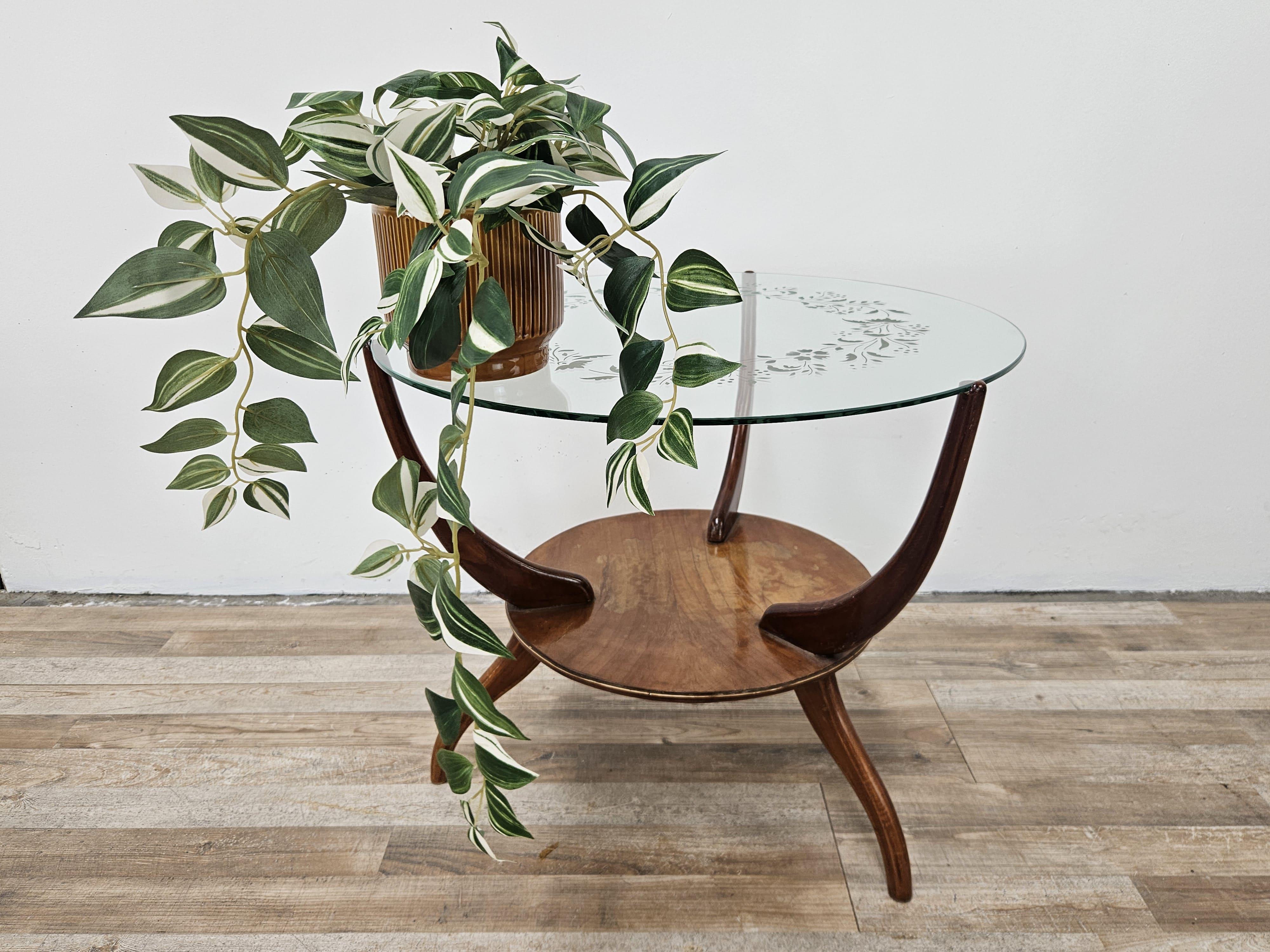 Tavolino da salotto anni '50 Art Decò con struttura in legno e piano in vetro lavorato con decori satinati.

Molto elegante e ricercato, grazie alle sue misure compatte e al design può essere utilizzato in un qualsiasi contesto antico o