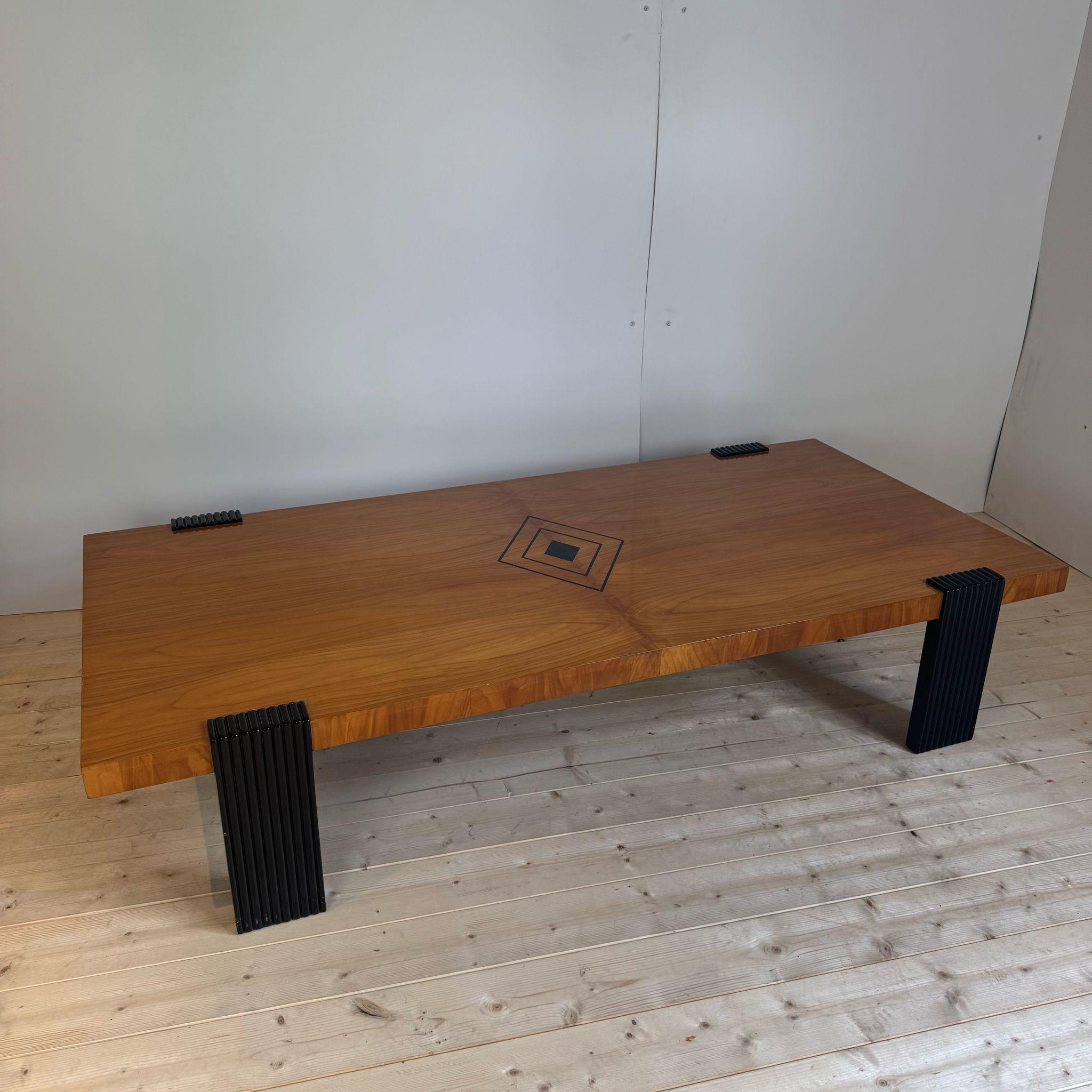 Fabriquée en Italie, cette table à café ou à cocktail surdimensionnée datant des années 1930 est dotée d'un plateau en bois blond, que nous pensons être du bouleau, d'un panneau graphique décoratif au centre et de pieds carrés contrastants avec une