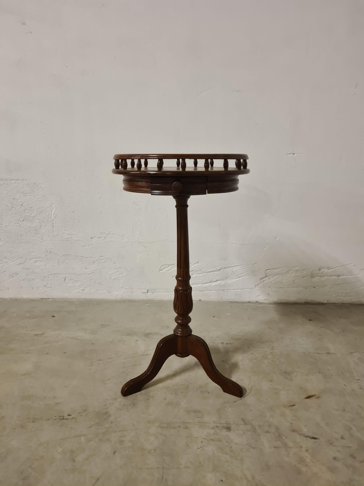 Tavolino circolare in noce produzione fine 800'

Raffinato tavolo da lampada con galleria a fuso.

Stile vittoriano, piano intarsiato con decori floreali in ottone e cassetto centrale.

La base è costituita da una colonna centrale con 3 gambe