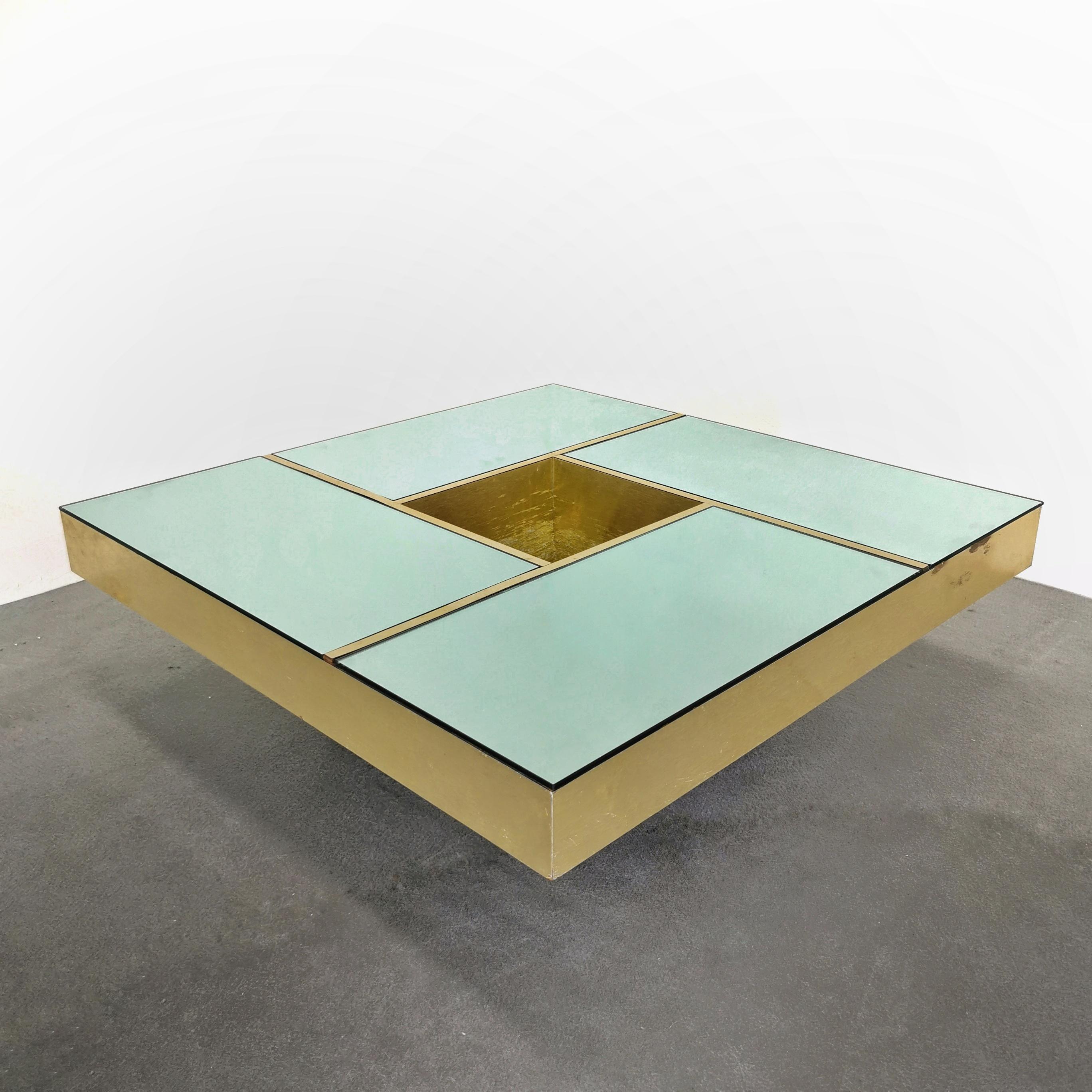 Quadratischer Couchtisch Modell 'Shilling', entworfen in den 1970er Jahren von Giovanni Ausenda, Guido Baldo Grossi & Gianni Gavioli für NY Form. Goldfarbener Tisch mit grüner Spiegelplatte, die durch goldene Bänder in vier Bereiche unterteilt ist.