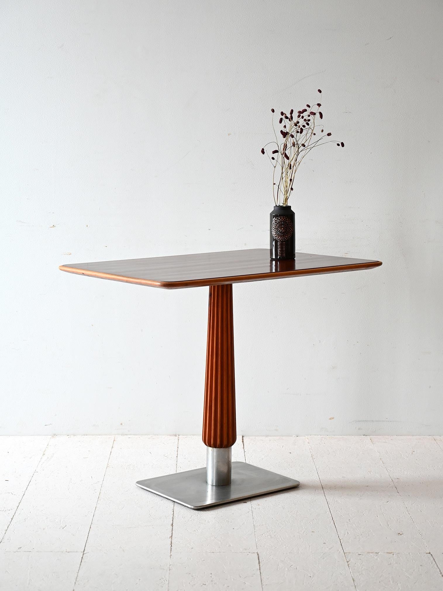 Table basse scandinave des années 1930 avec plateau en acajou, tige sculptée et base carrée en acier brossé.

Élégance compacte et goût Art déco pour cette table de bar scandinave des années 1930. Le plateau en acajou est soutenu par une tige