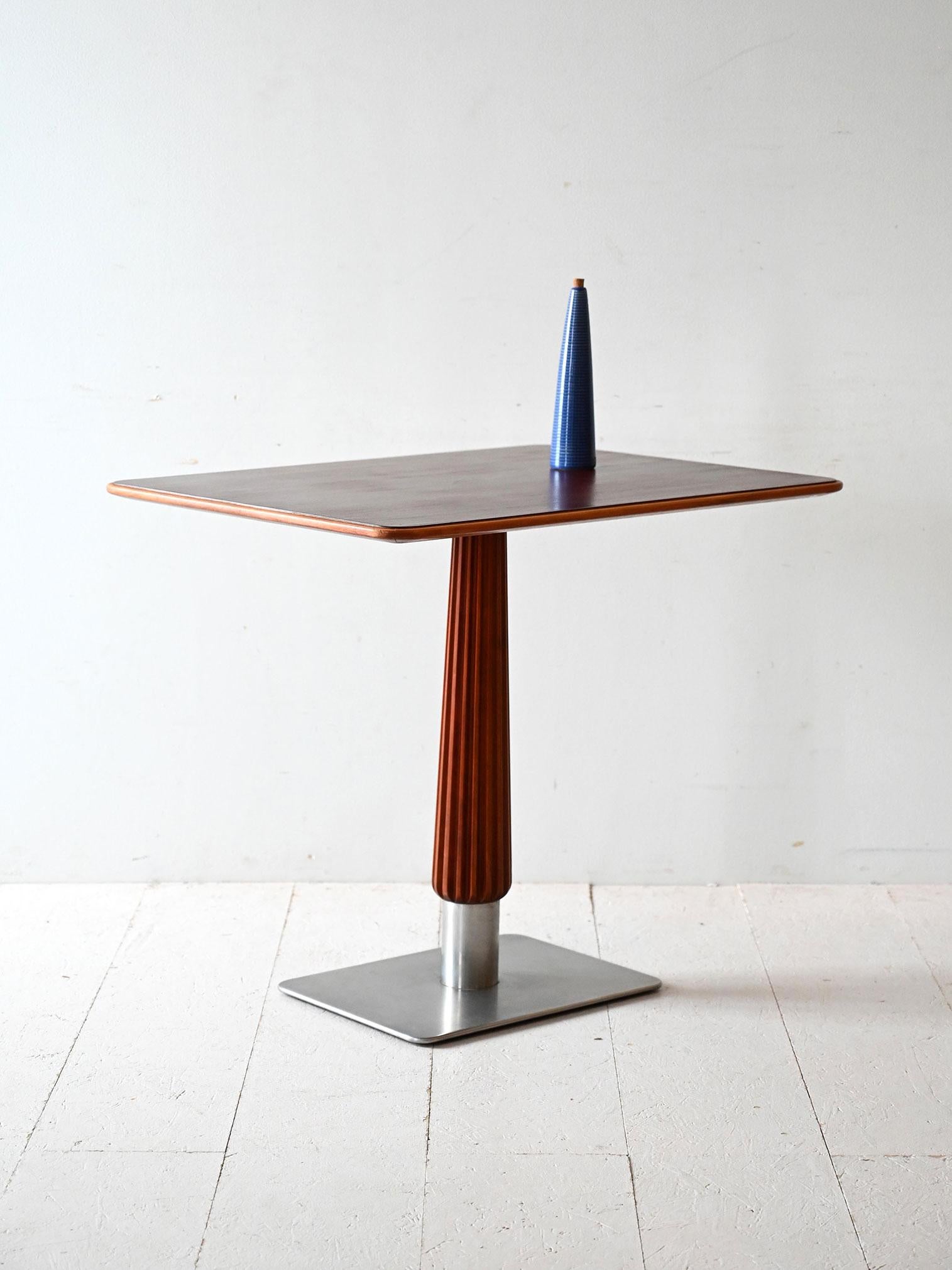 Table basse scandinave des années 1930 avec plateau en acajou, tige sculptée et base carrée en acier brossé.

Élégance compacte et goût Art déco pour cette table de bar scandinave des années 1930. Le plateau en acajou est soutenu par une tige