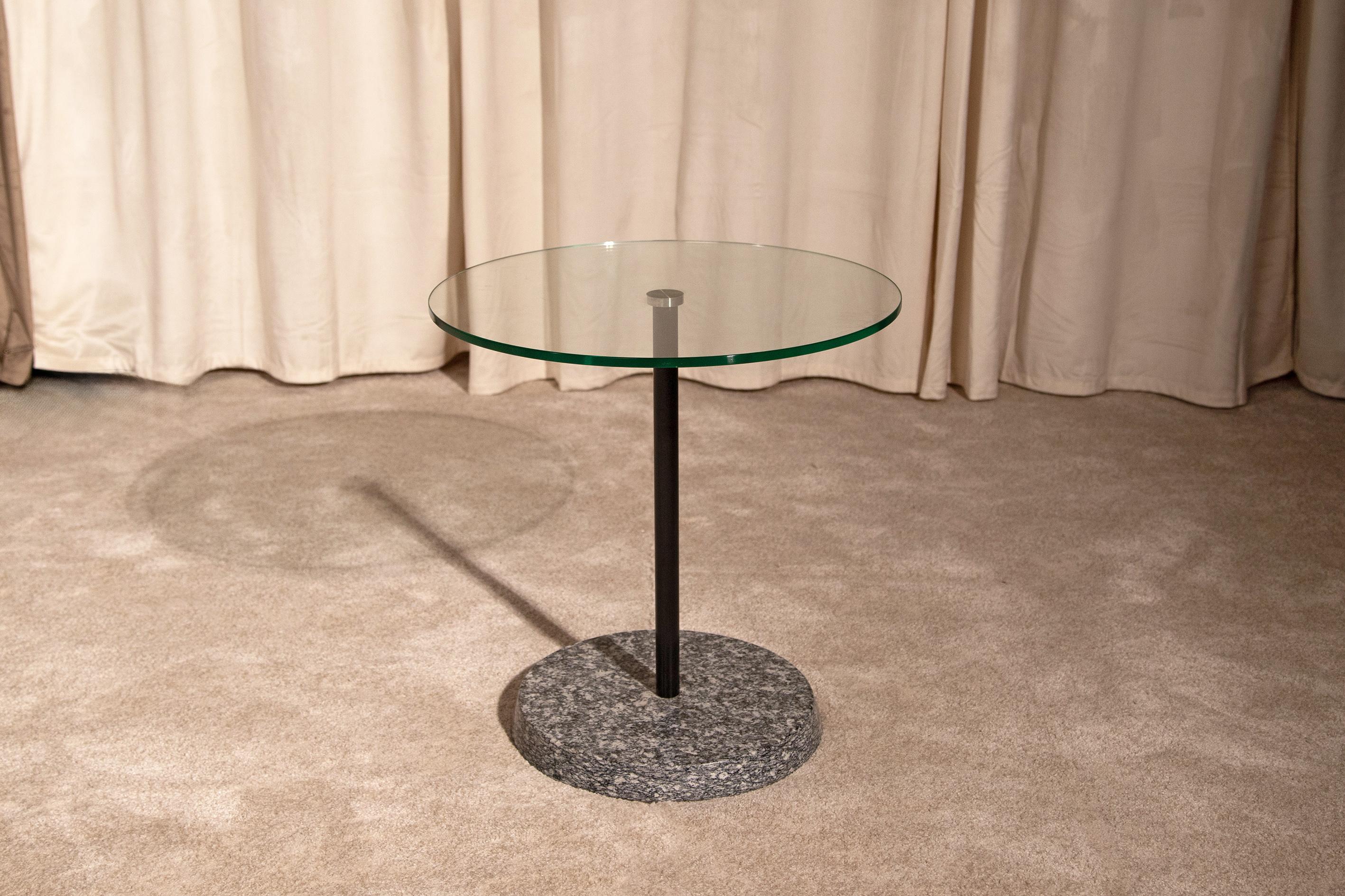 Élégante table basse postmoderne des années 1980 avec plateau en verre, pied en métal peint en noir et base en granit gris. Excellent état. Fabriqué en Italie.