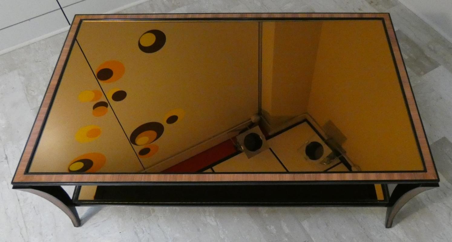 Elegante e scenico Tavolino da Caffè in Acciaio Laccato nero decorato a mano e doppio ripiano in Cristallo Ambrato originale.
Il design Classico fu reinterpretato realizzando la struttura in acciaio e i sui decori che replicavano gli intarsi Decò in