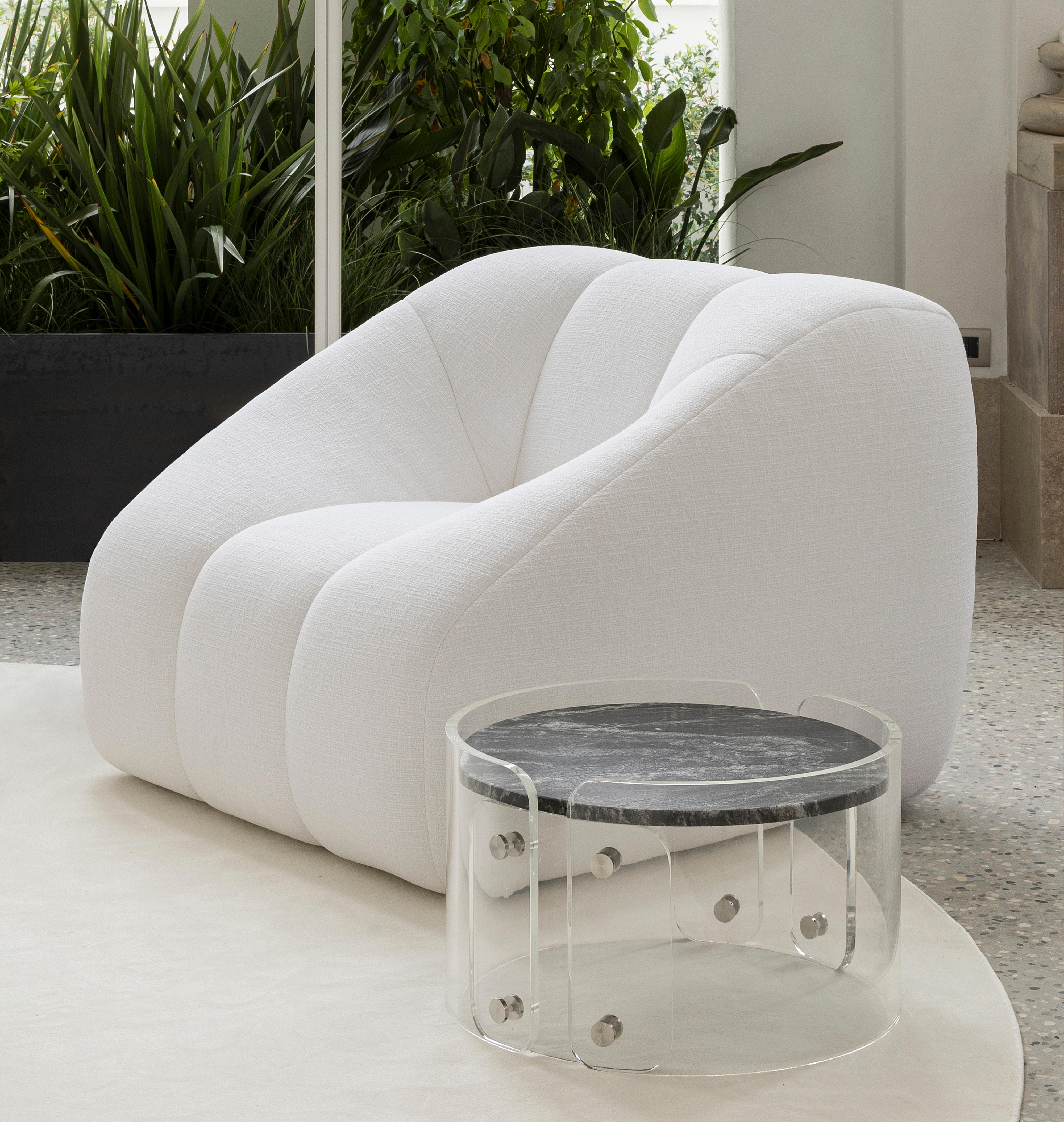 Conçue par le designer brésilien Ricardo Antonio, la table basse Lassù se distingue par la simplicité avec laquelle elle associe deux matériaux très différents : la pierre et le plexiglas. Le plateau est en granit noir beauty, un matériau riche dont