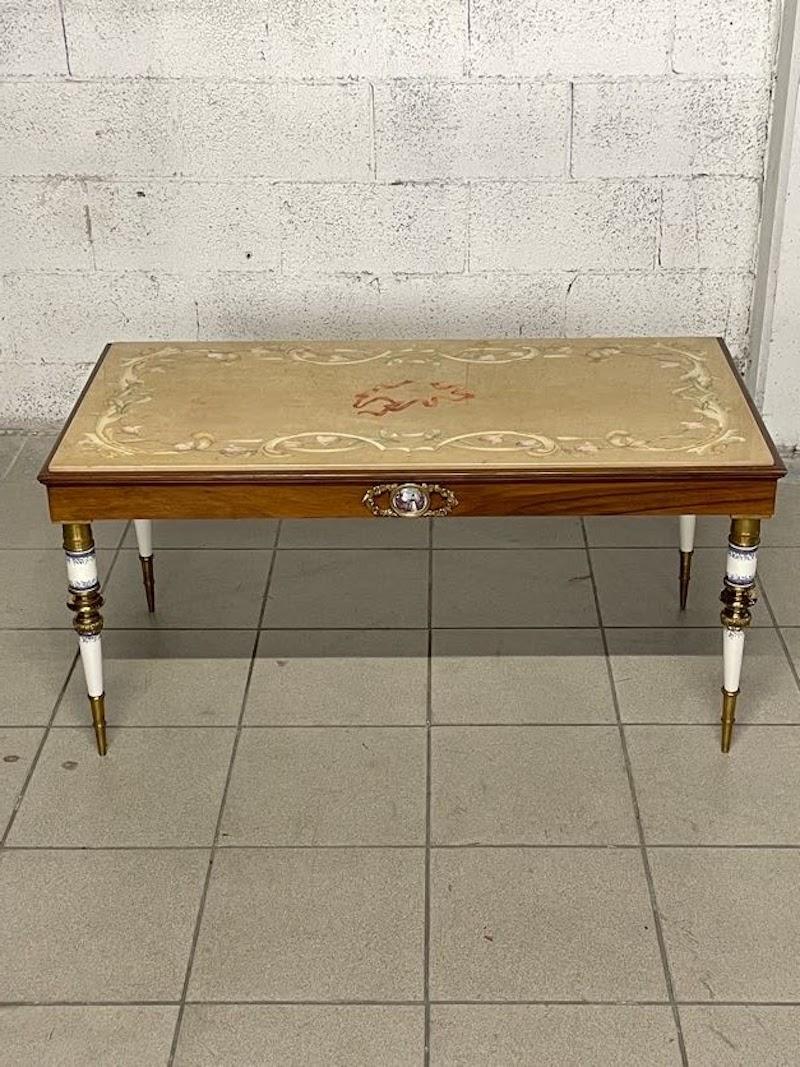Sofa oder Couchtisch aus den 1950er Jahren aus italienischer Produktion und von hoher Qualität.

Der Tisch weist die folgenden Herstellungsbesonderheiten auf:
- horizontaler Mahagoni-Balken mit zentralem Medaillon aus Bronze und Keramik;

- füße aus