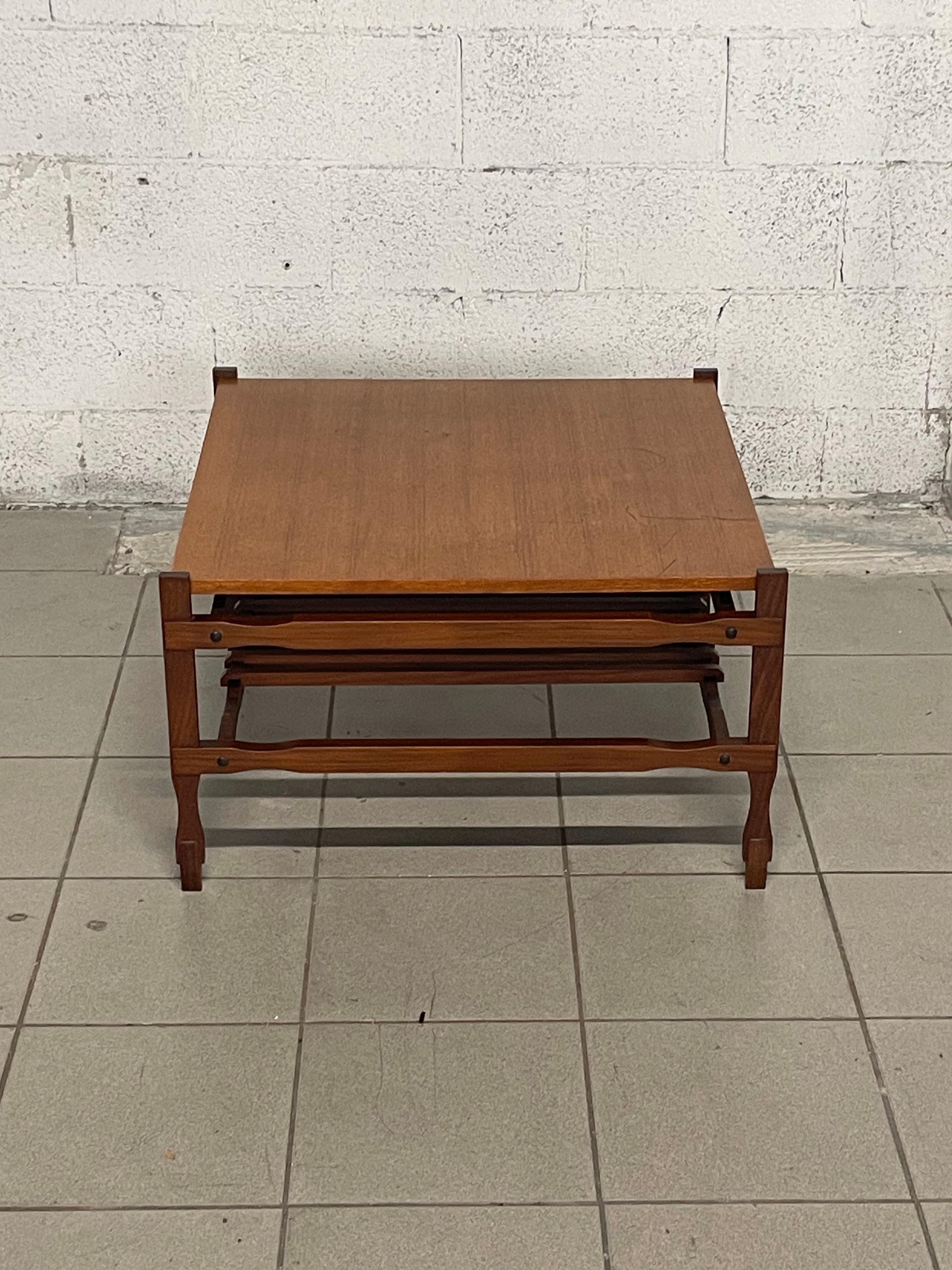 Teak coffee table from the 1960s.

The slatted structure characterizes this side table in its side parts and the shelf underneath, which can also be used as a magazine rack.

The coffee table is in excellent condition.