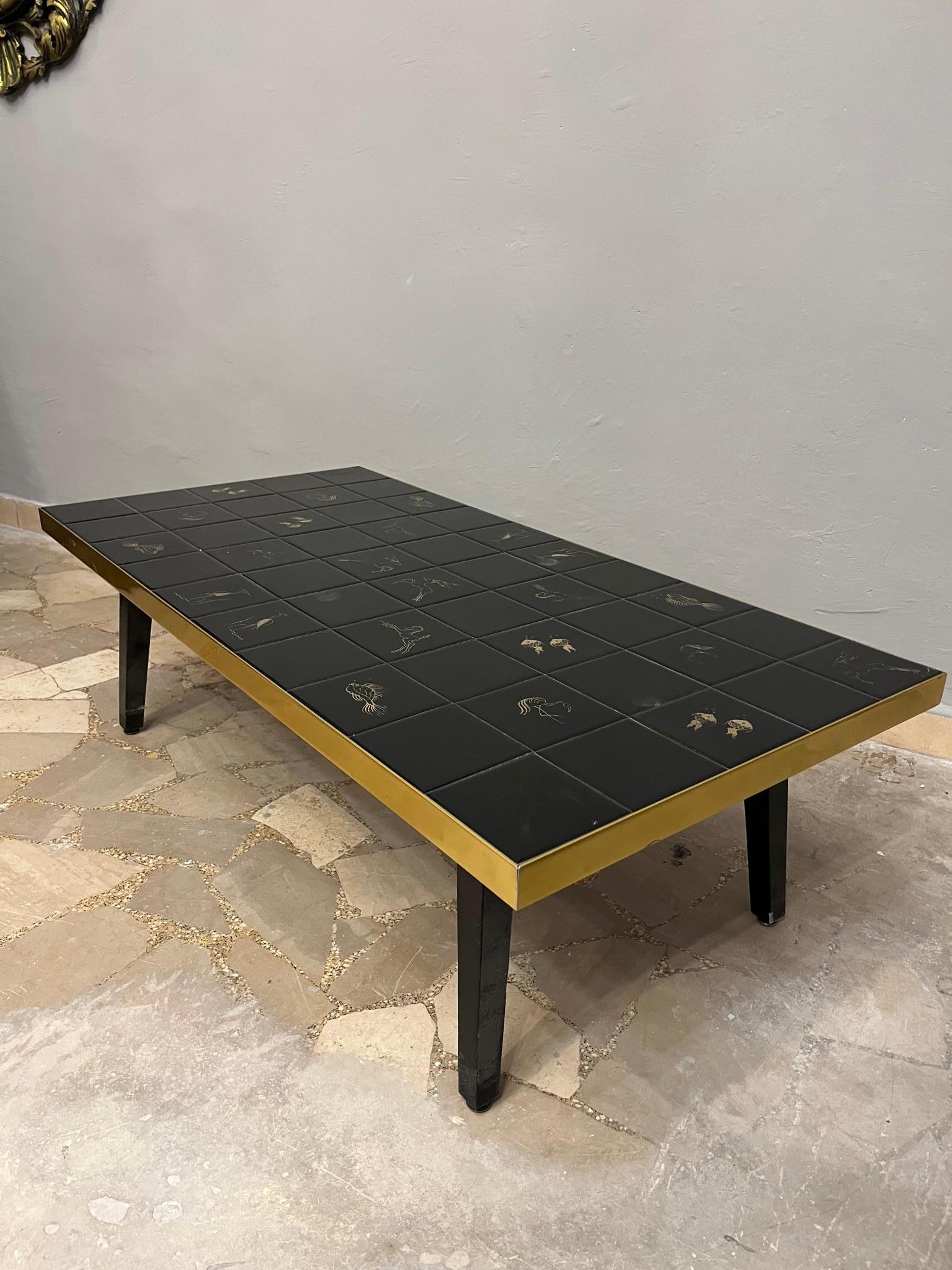 Low Coffee Table Living Room Wood and Black Majolica Decorated Gold Vintage 1970s -Design-

Anno: 1970 circa 

Materials: Wood, Brass, Black majolica tiles with Gold decoration

Condizioni: Molto Buone 

Measures: 

Cm 110 x cm 55 x cm 35h 