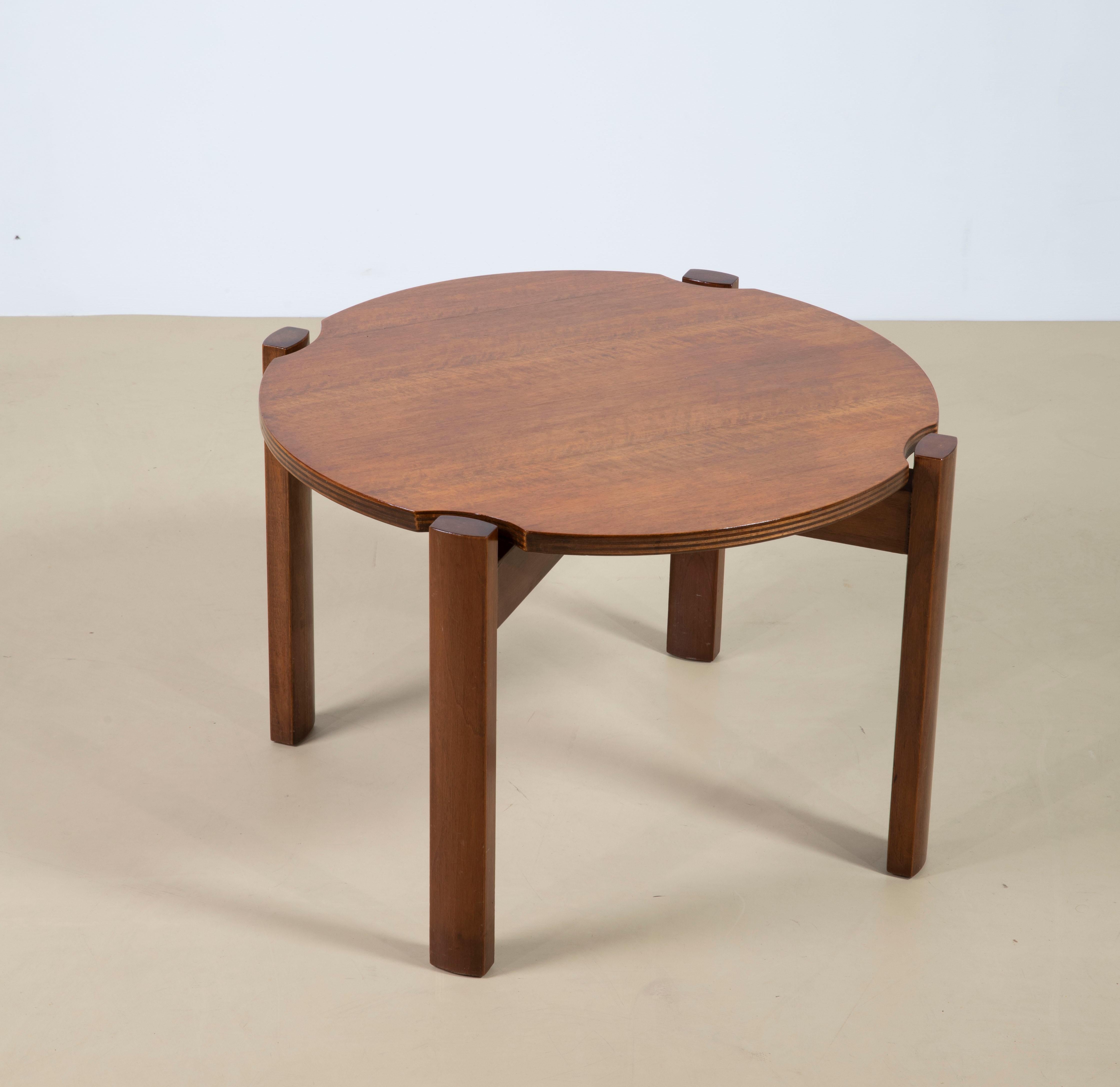 Table basse particulière des années 1960, de fabrication italienne, avec un plateau caractéristique en contreplaqué multicouche dans les tons d'acajou et façonné près de l'articulation du pied.