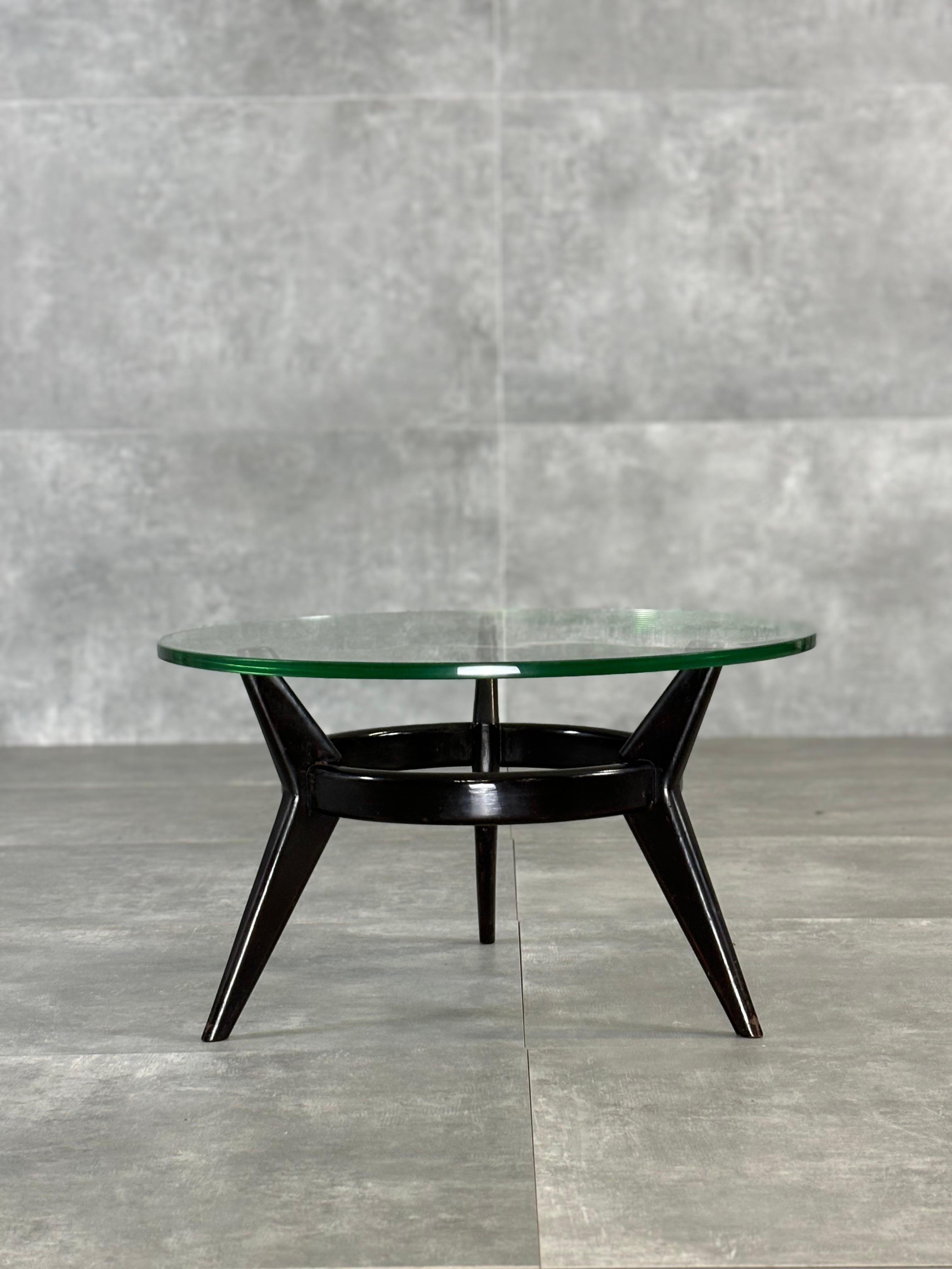 The coffee table has a three-leg support structure with a curious boomerang design, made of ebony-stained wood, joined by a horizontal ring, also made of wood, that completes and stabilizes the whole. The top is made of crystal.
Archived furniture: