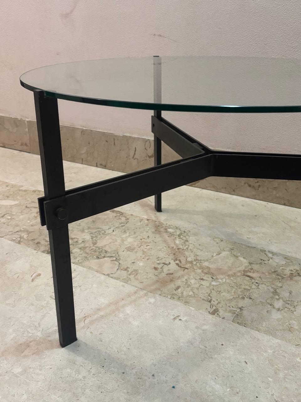 La table basse en question, avec son design minimaliste et sa base métallique en forme de 