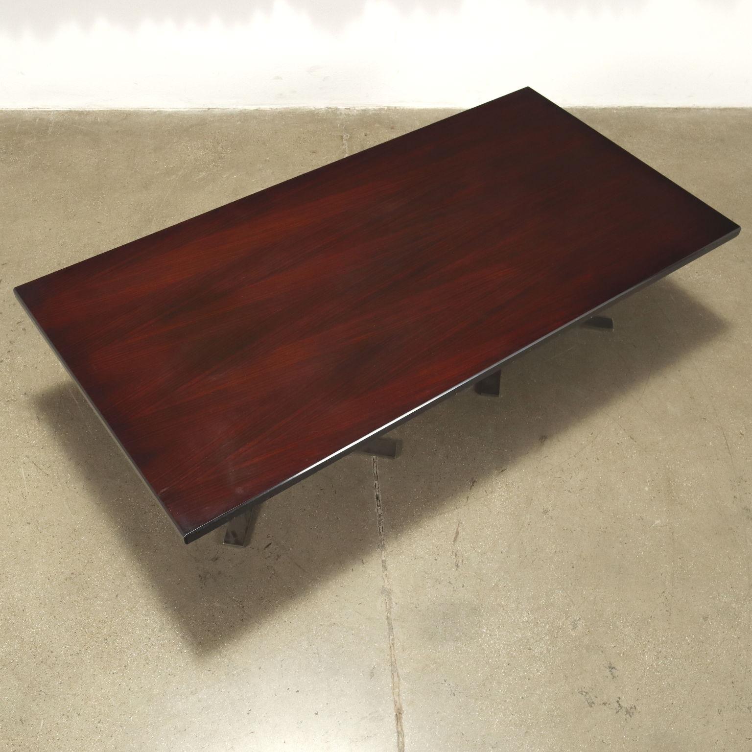 Table centrale ; placage de bois exotique teinté, base en métal chromé. Bon état.