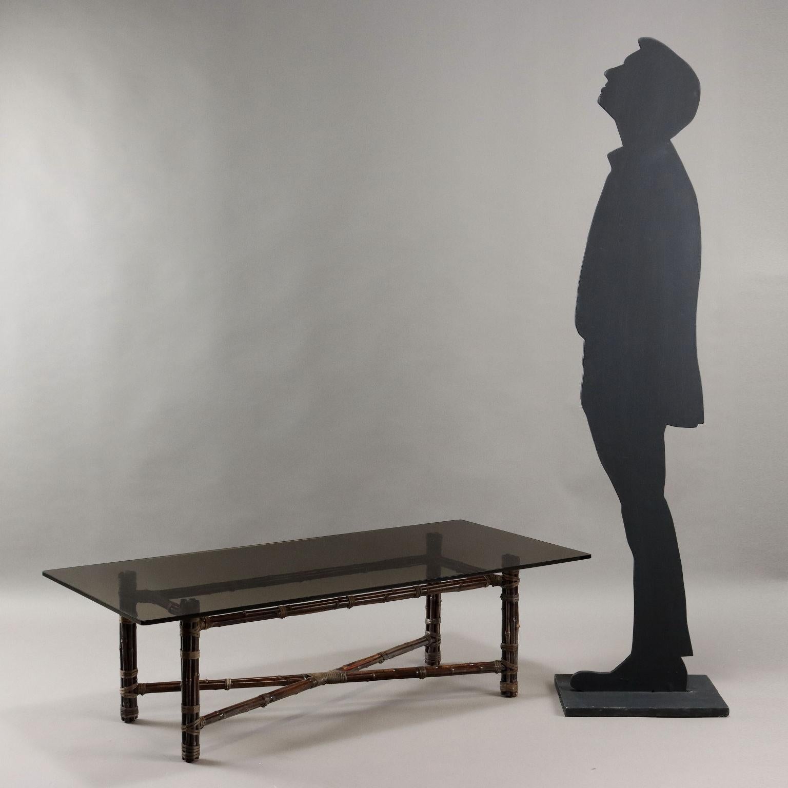 Table basse avec base en bambou, plateau en verre fumé. 