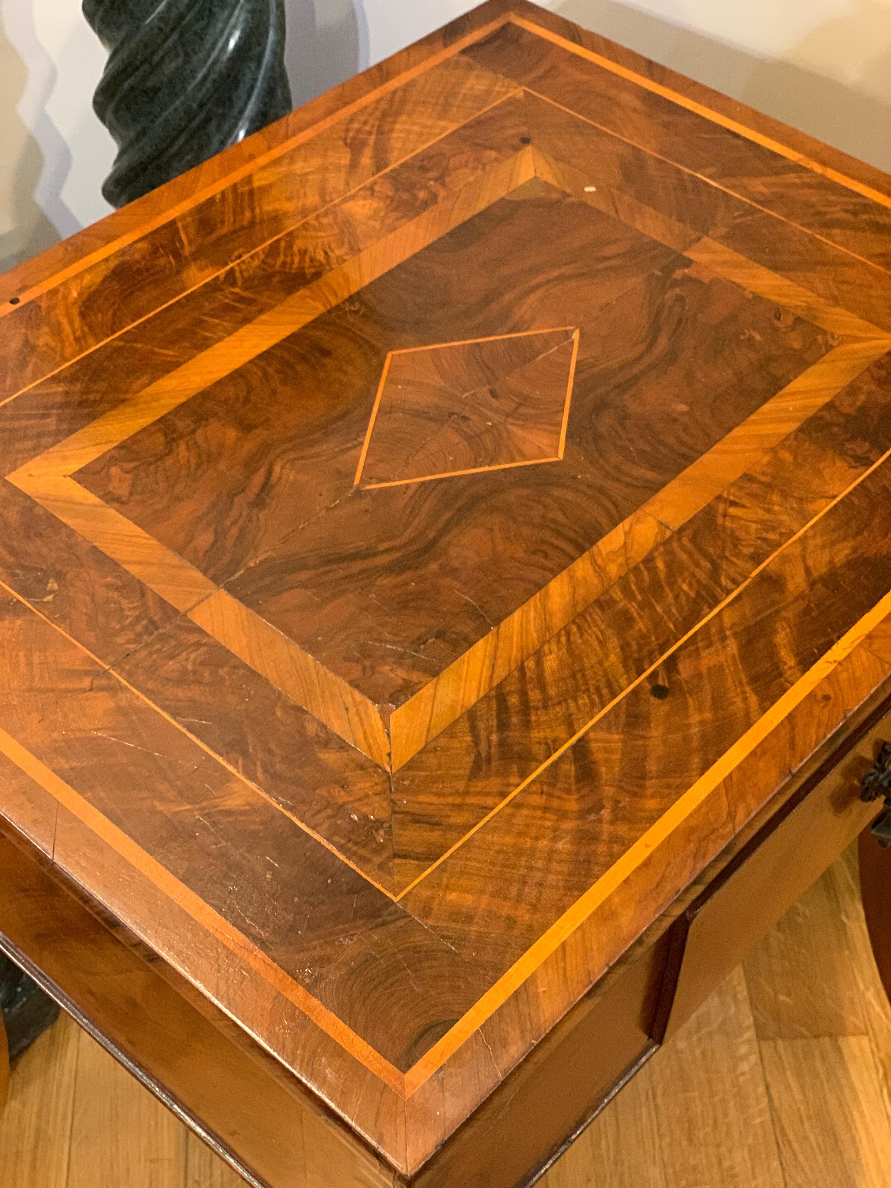 Elegant Directoire small table inlaid with various fruit essences with geometric motifs. Typical saber leg used in the transition period between Louis XVI and the Empire, especially in Tuscany. The table has a very comfortable central drawer and is