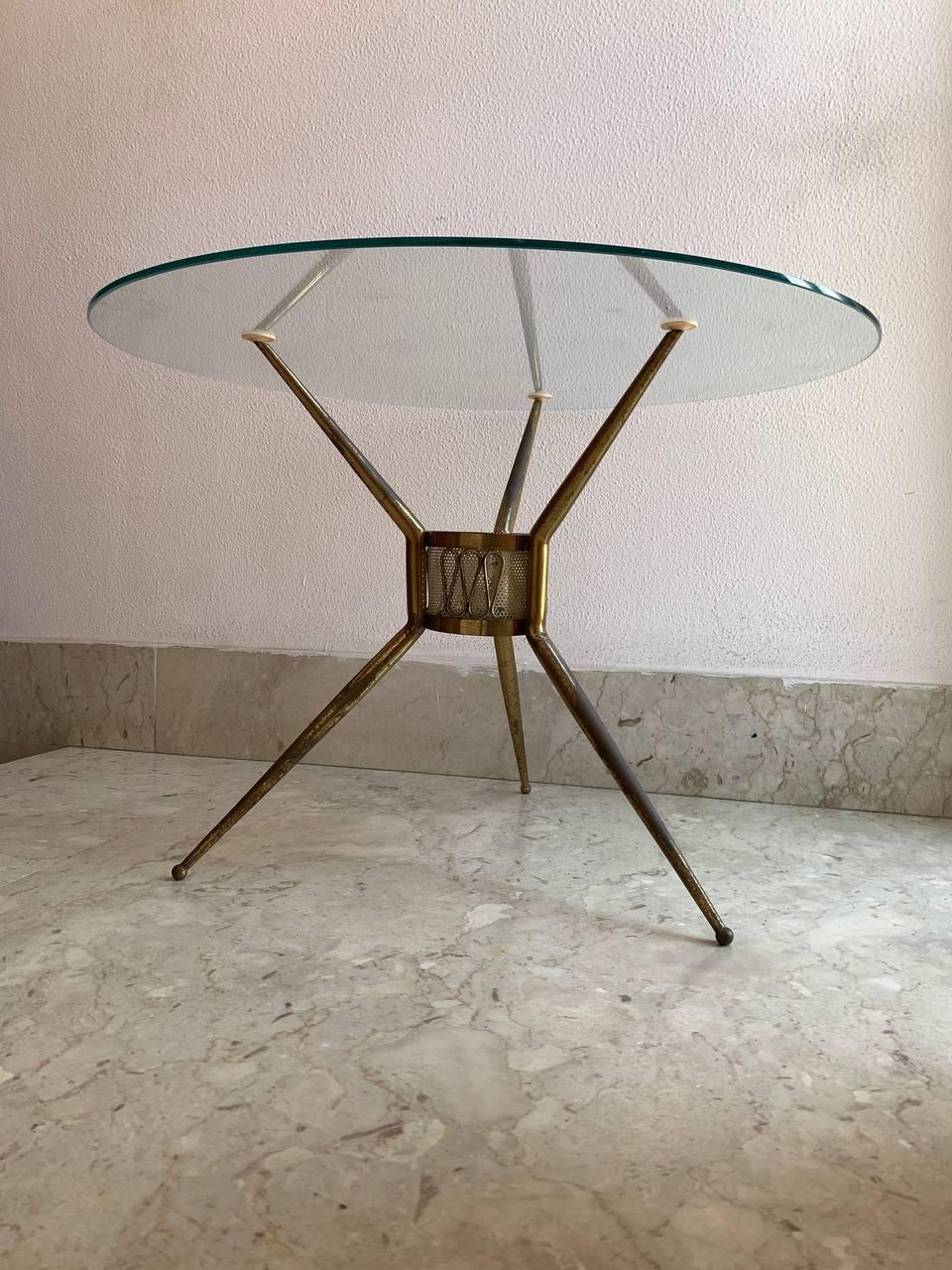 This coffee table designed by Giò Ponti embodies the timeless elegance and innovation of 20th-century Italian design. Featuring a tripod frame with a central key holder support in patinated brass, the coffee table has essential and refined lines