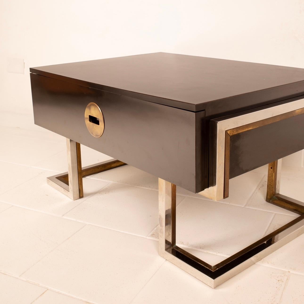 Stunning coffee table or bedside table designed and produced by Romeo Rega in the 1970s.
The coffee table is made of black laminated wood with brass and chrome-plated steel legs in excellent condition.
There is a large drawer com brass handle where