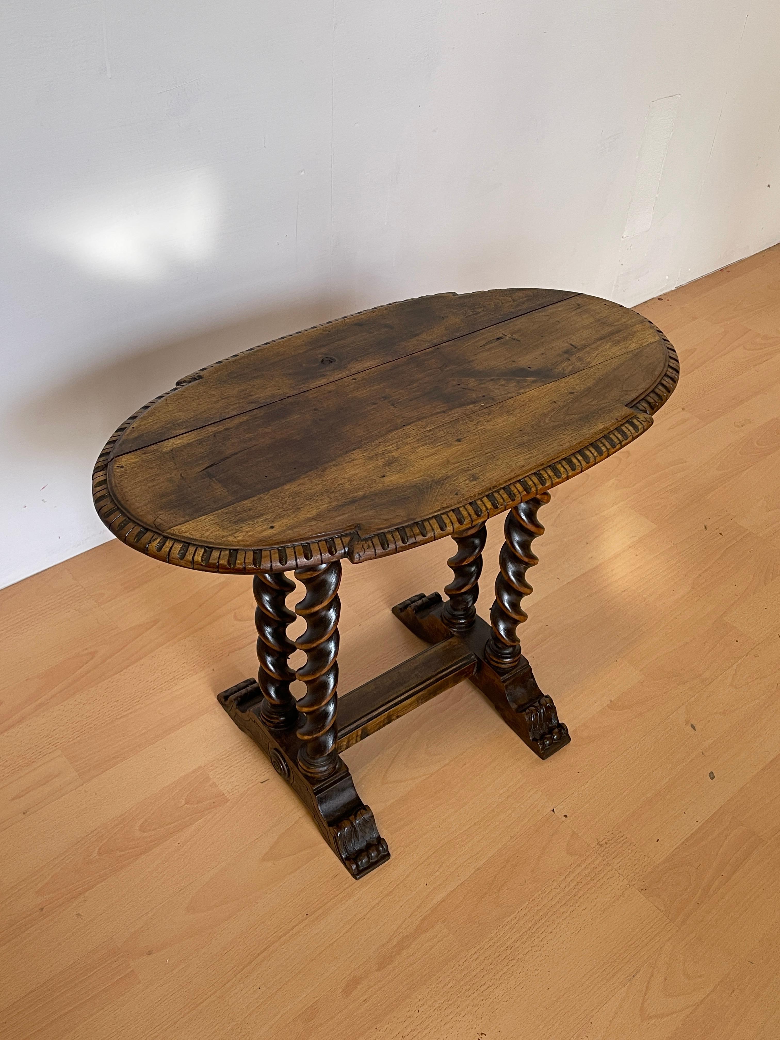 Un elegante tavolino in legno massello con un design classico e raffinato, caratterizzato da un piano ovale finemente lavorato e da gambe tornite a spirale. Il tavolo è sostenuto da una solida base intagliata che conferisce una grande stabilità,