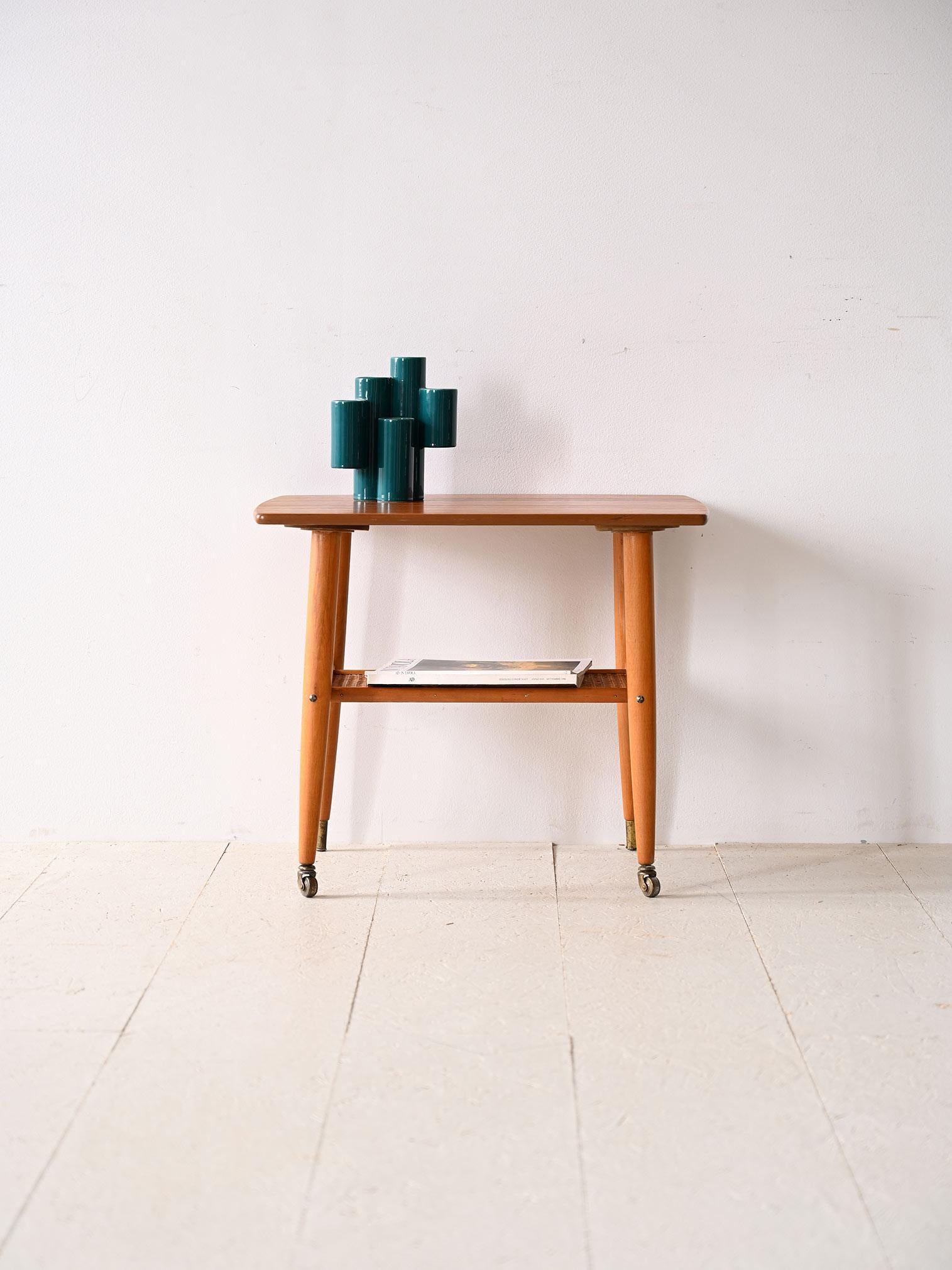 Vintage Couchtisch mit Rädern.

Ein skandinavisch-modernes Möbelstück mit nüchternen und eleganten Linien. Es zeichnet sich durch die Form der Platte mit abgerundeten Ecken, konisch zulaufenden Beinen mit Messingzwinge und Rollen sowie einer