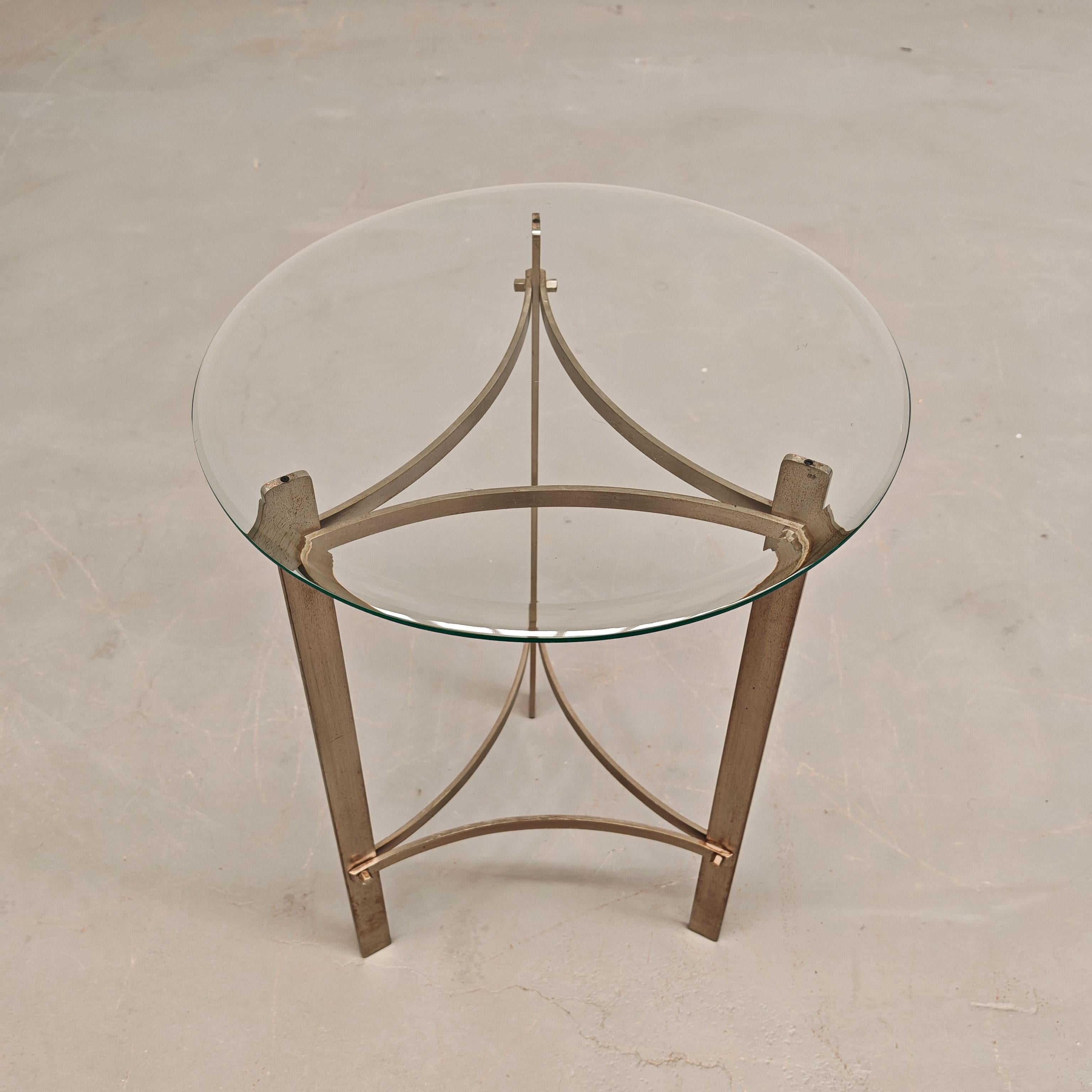 Table basse avec structure en métal en laiton nickelé et plateau en verre avec bodo travaillé.
La table basse est en très bon état avec une vis remplacée (visible sur la photo) et le verre est en excellent état
