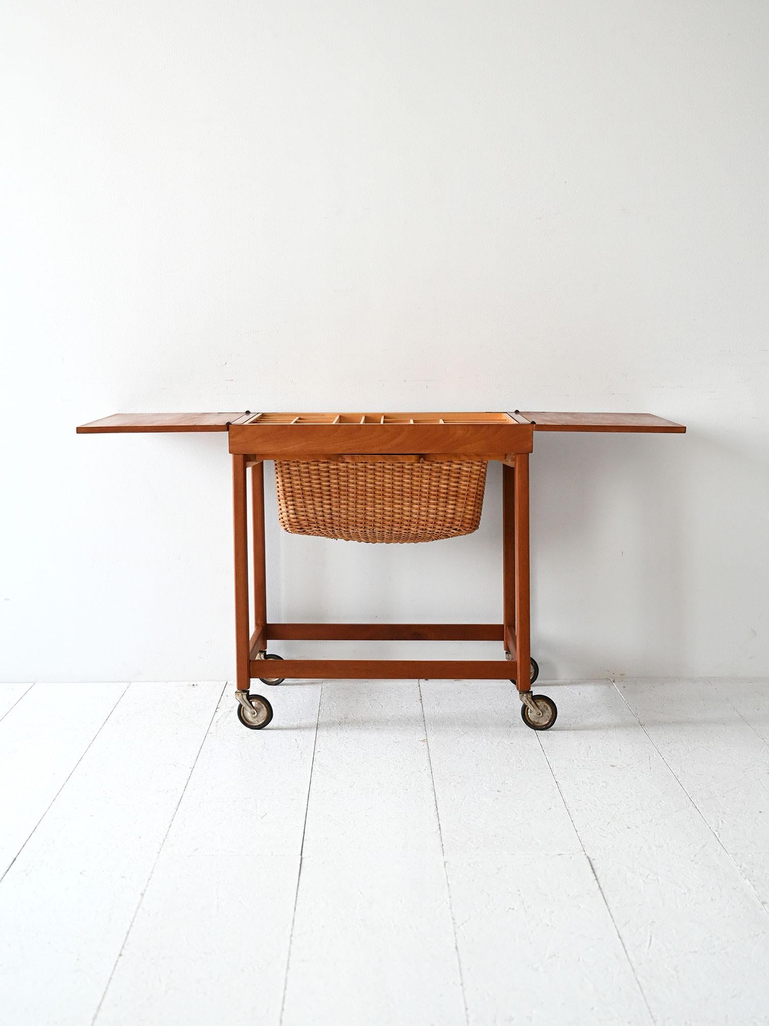 Tavolino da lavoro anni ’60 con rotelle originali, cestello in vimini estraibile e vassoio portaoggetti con divisori.

Tavolino portalana scandinavo degli anni ’60, con struttura in legno massello, rotelle originali e cestello in vimini estraibile.