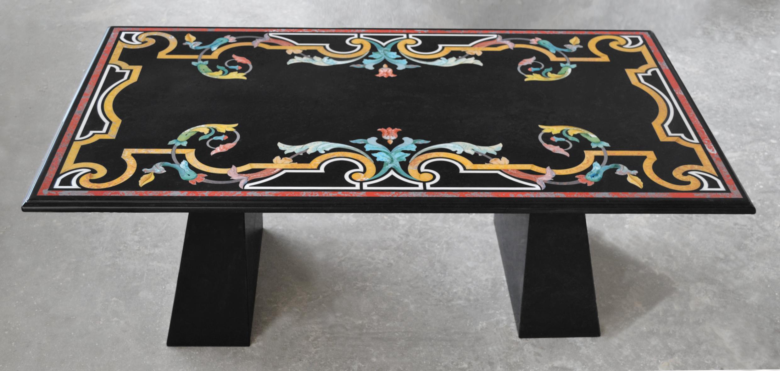Tavolino da salotto realizzato con la tecnica decorativa dell' intarsio in scagliola su piano in marmo Nero, che appoggia su di un basamento in legno laccato nero dalla sagoma trapezoidale.
Le capacità  artistiche  vengono messe a disposizione  per