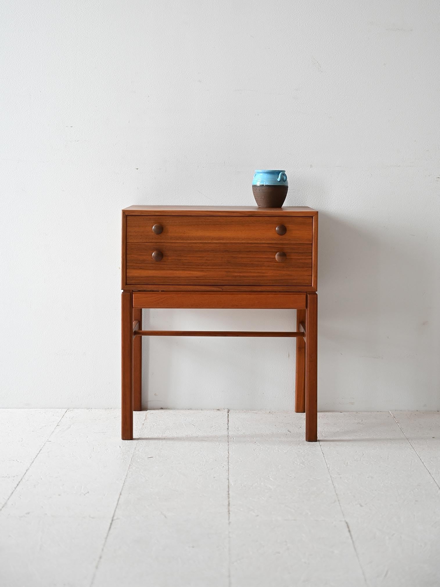 Tavolino originale anni '60 prodotto in Svezia. Si distingue per il piano quadrato e la presenza di due cassetti con pomelli in legno. 

Le linee moderne e le marcate venature del legno lo rendono un pezzo d'arredo elegante e dalla bellezza senza
