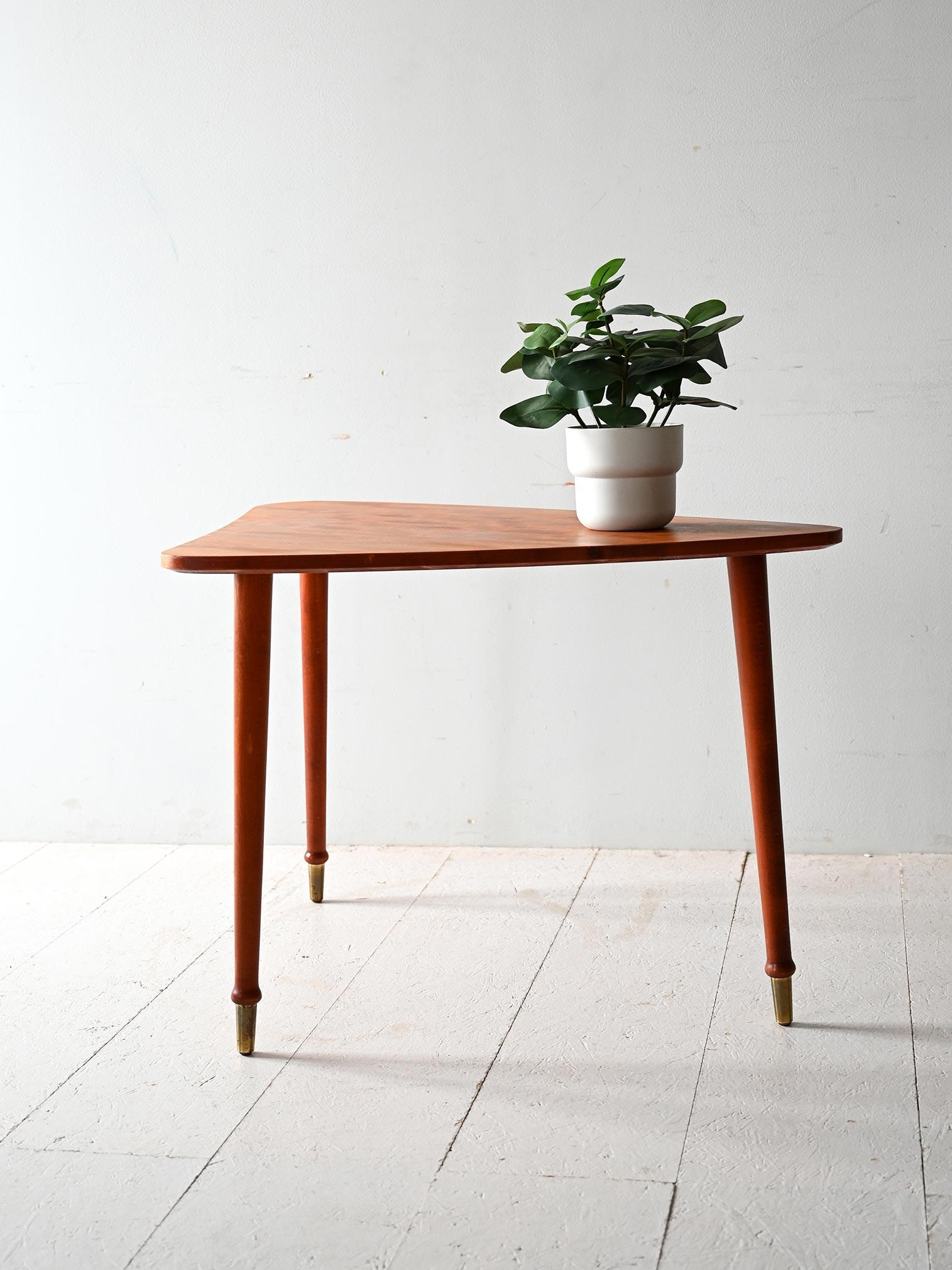 Vintage Scandinavian coffee table with organic shapes, tapered legs and brass feet. Mahogany frame with beveled corners.

Scandinavian 1950s/60s coffee table with triangular top with rounded edges and organic shapes. Made of mahogany, it has a