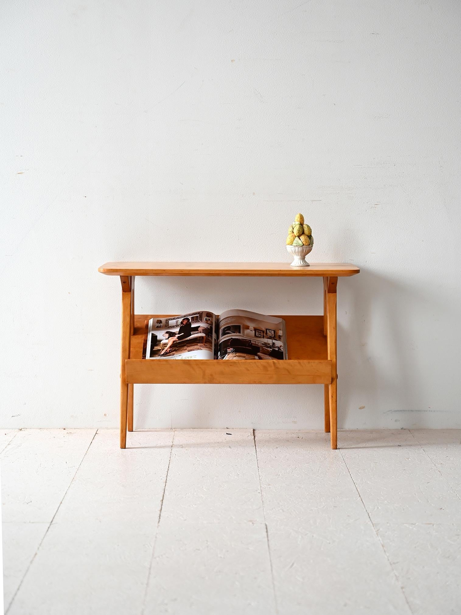 Tavolino in betulla con ripiano superiore e vano espositore inclinato. Struttura leggera con gambe slanciate e dettagli curati.

Tavolino scandinavo della metà del Novecento interamente realizzato in betulla. Il piano superiore ha angoli smussati,