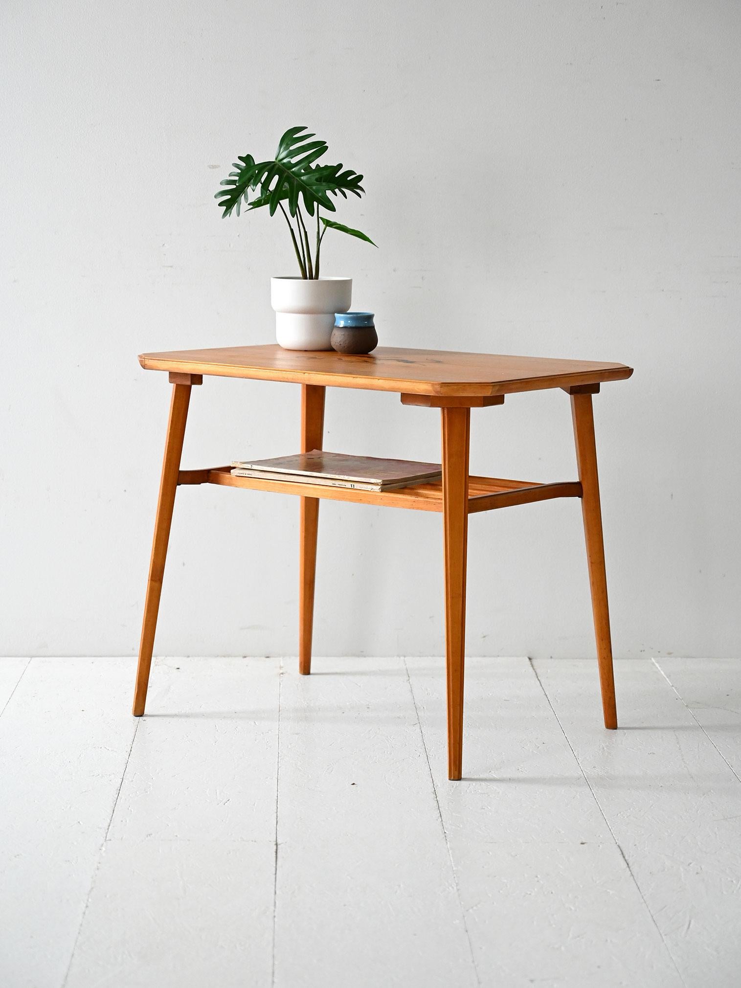 Tavolino scandinavo anni 40/50 in betulla con piano intarsiato a motivi figurativi e ripiano inferiore a listelli.

Tavolino scandinavo vintage degli anni 40/50 realizzato in betulla, con elegante piano a intarsio raffigurante soggetti figurativi
