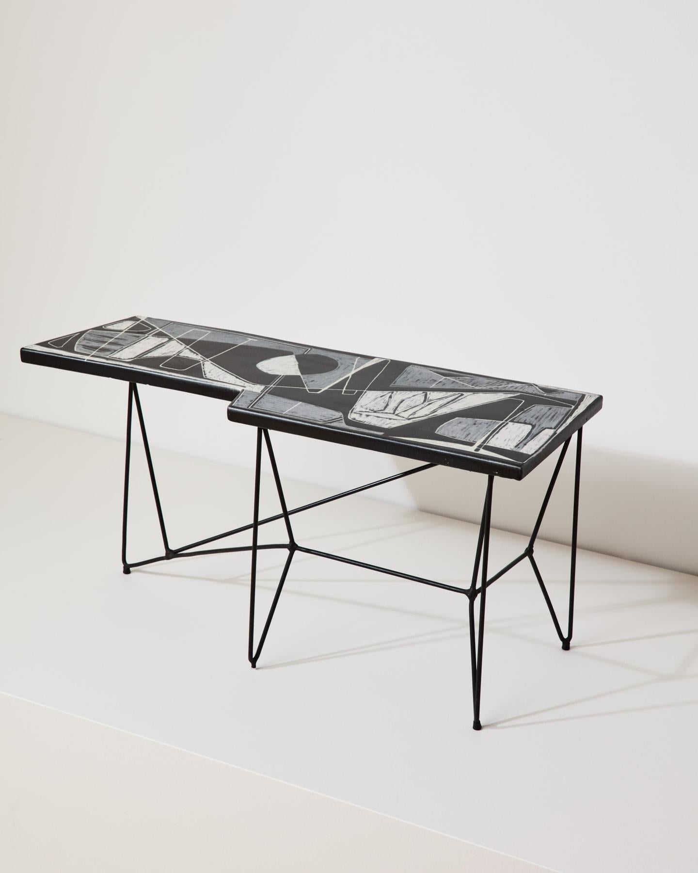 Table-sculpture raffinée avec plateau en céramique aux motifs abstraits, dans la combinaison de couleurs blanc/gris/noir, avec de fins pieds en fer aux lignes géométriques. Réalisé par Victor Cerrato, céramiste et sculpteur piémontais, vers 1950.