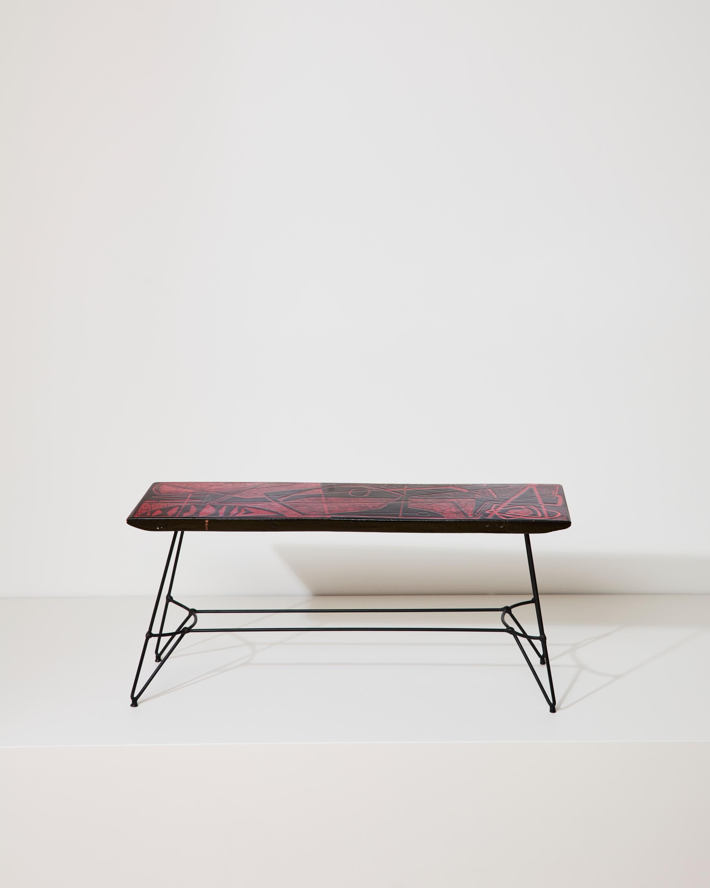 Raffinato tavolino-scultura con piano in ceramica dai motivi astratti, nella combinazione di colori rosso/nero, con sottili piedi in ferro dalle linee geometriche. Realizzati da Victor Cerrato, ceramista e scultore piemontese, nel 1950 circa.