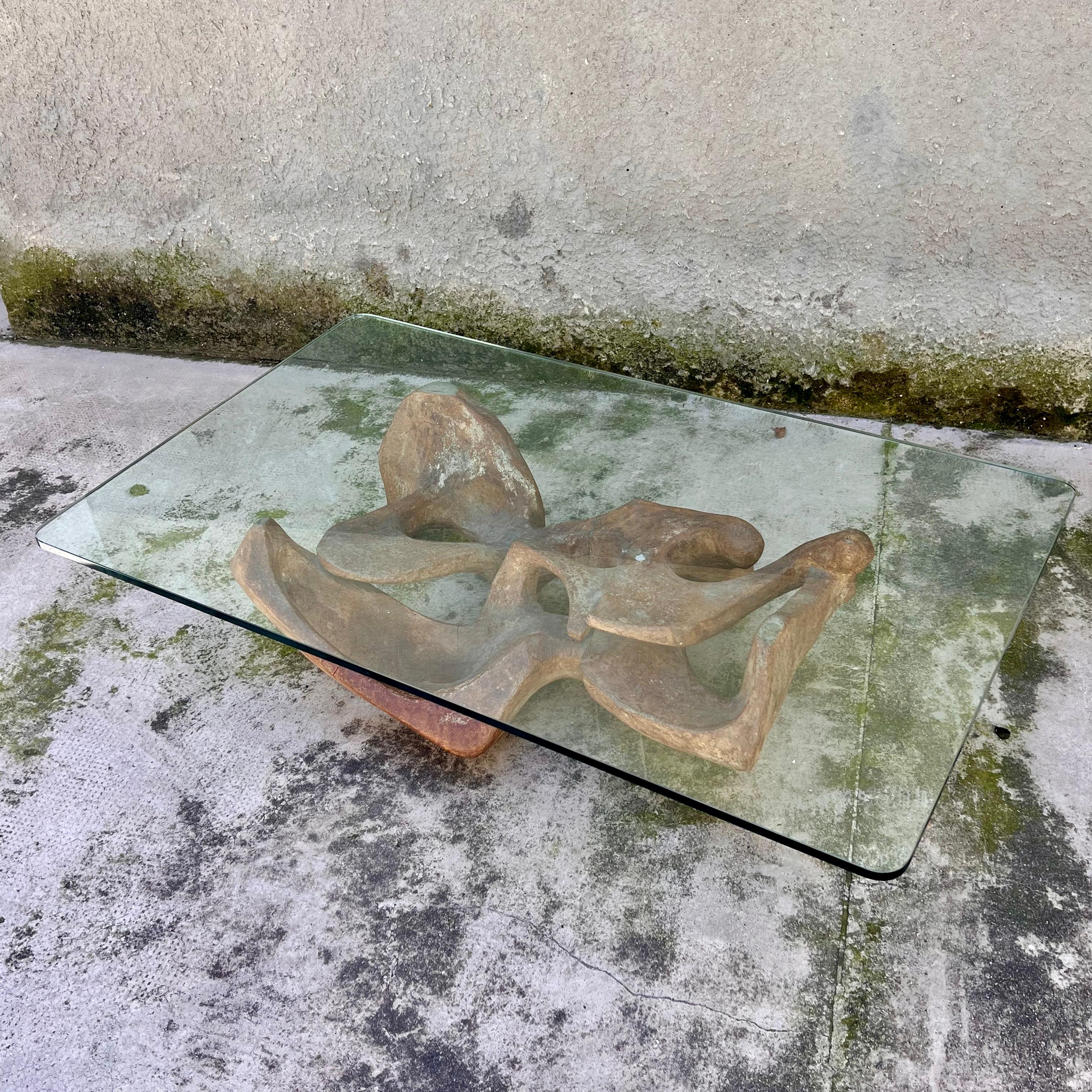 Ipnotico questo tavolino; da qualunque angolazione lo si guardi, lo si vede e lo si interpreta in maniera diversa.
La scultura che regge il vetro, realizzata in cemento con un'anima in ferro (quasi sicuramente), ha una forma antropomorfa che lascia