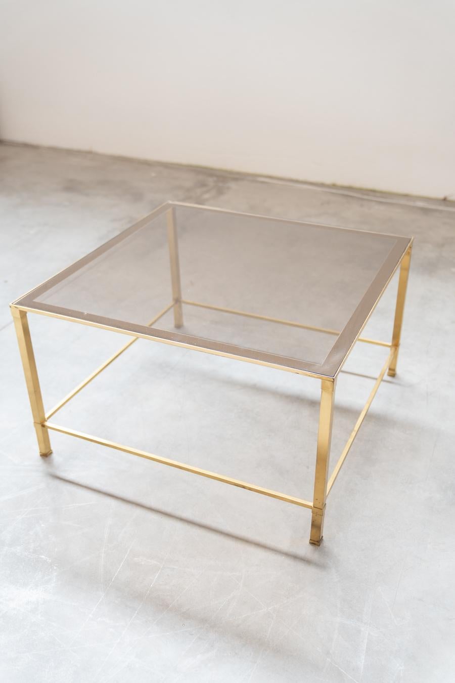 Guy Lefevre living room side table, France, 1970       
Elegant brass frame, clear smoked glass top. Excellent original condition, brass finish virtually intact. Both glass tops are in perfect condition with no chips or damage.
DESIGN PERIOD        