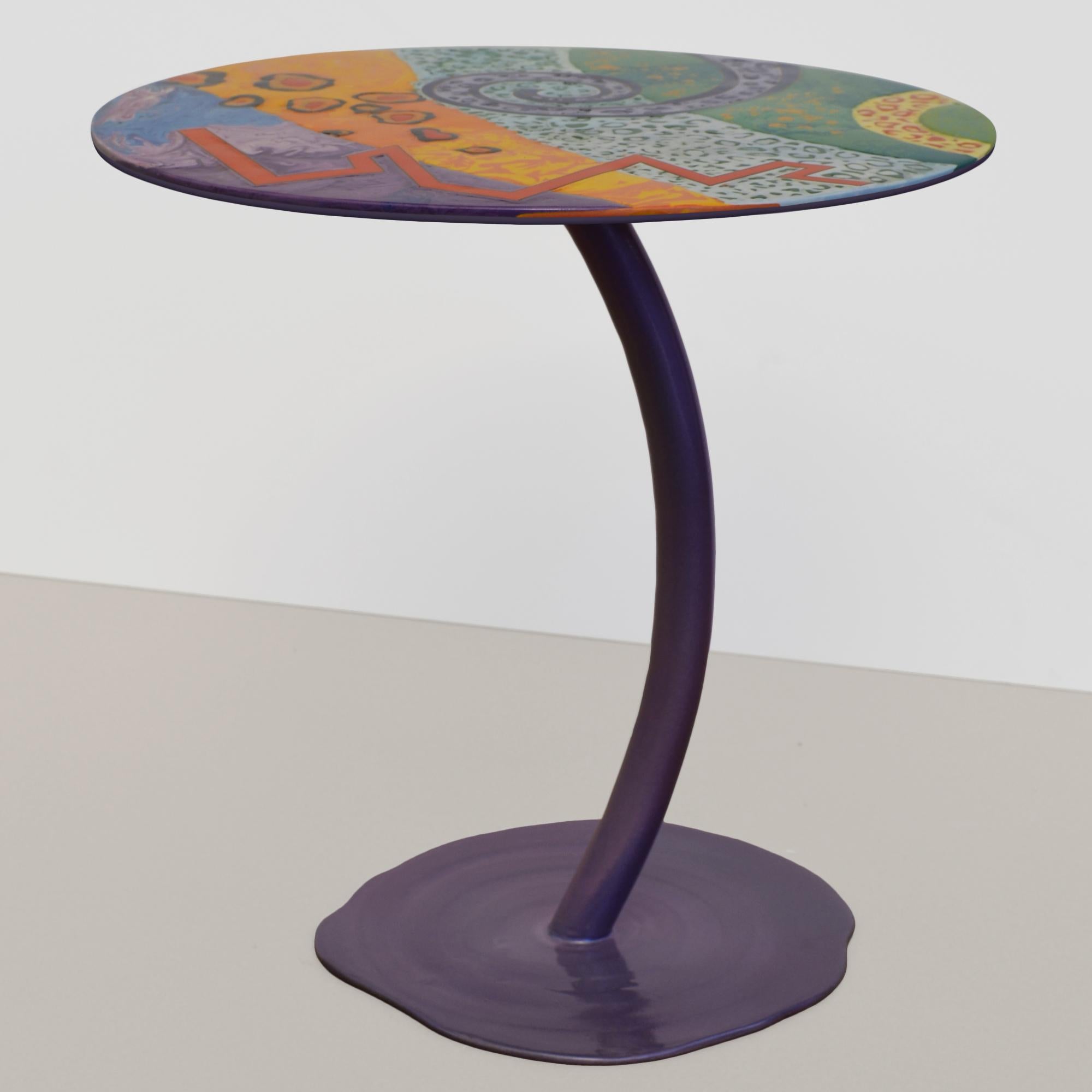 Tavolino top decorato, base ferro viola cangiante  fatto a mano in Italia da Cupioli .
Il tavolino Cromia è un complemento d’arredo dal design unico, che unisce eleganza e creatività. La sua base slanciata dai colori cangianti, sostiene un piano