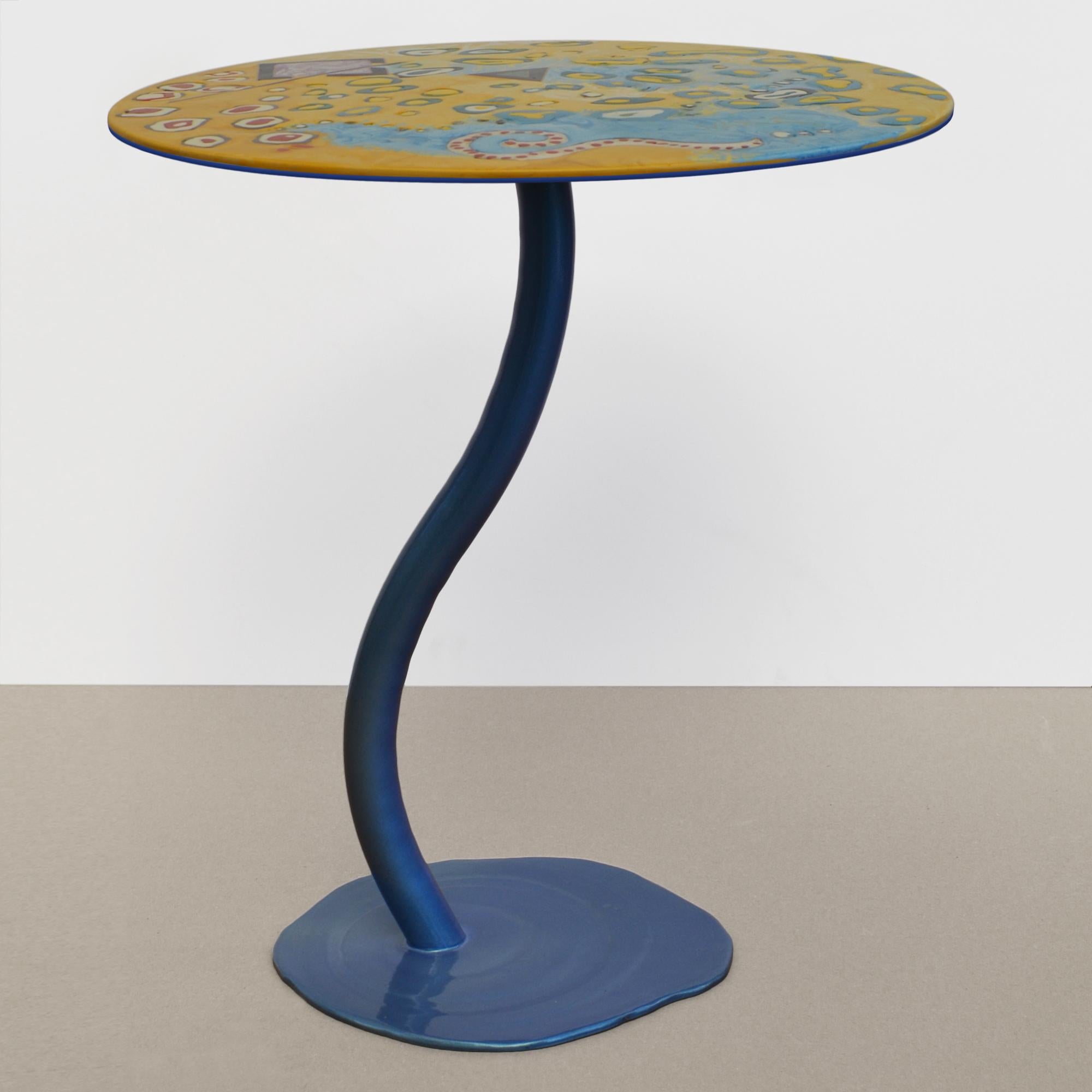 Il tavolino Cromia è un complemento d’arredo dal design unico, che unisce eleganza e creatività. La sua base slanciata dai colori cangianti, sostiene un piano decorato con motivi astratti, creando un effetto dinamico e sempre diverso a seconda della