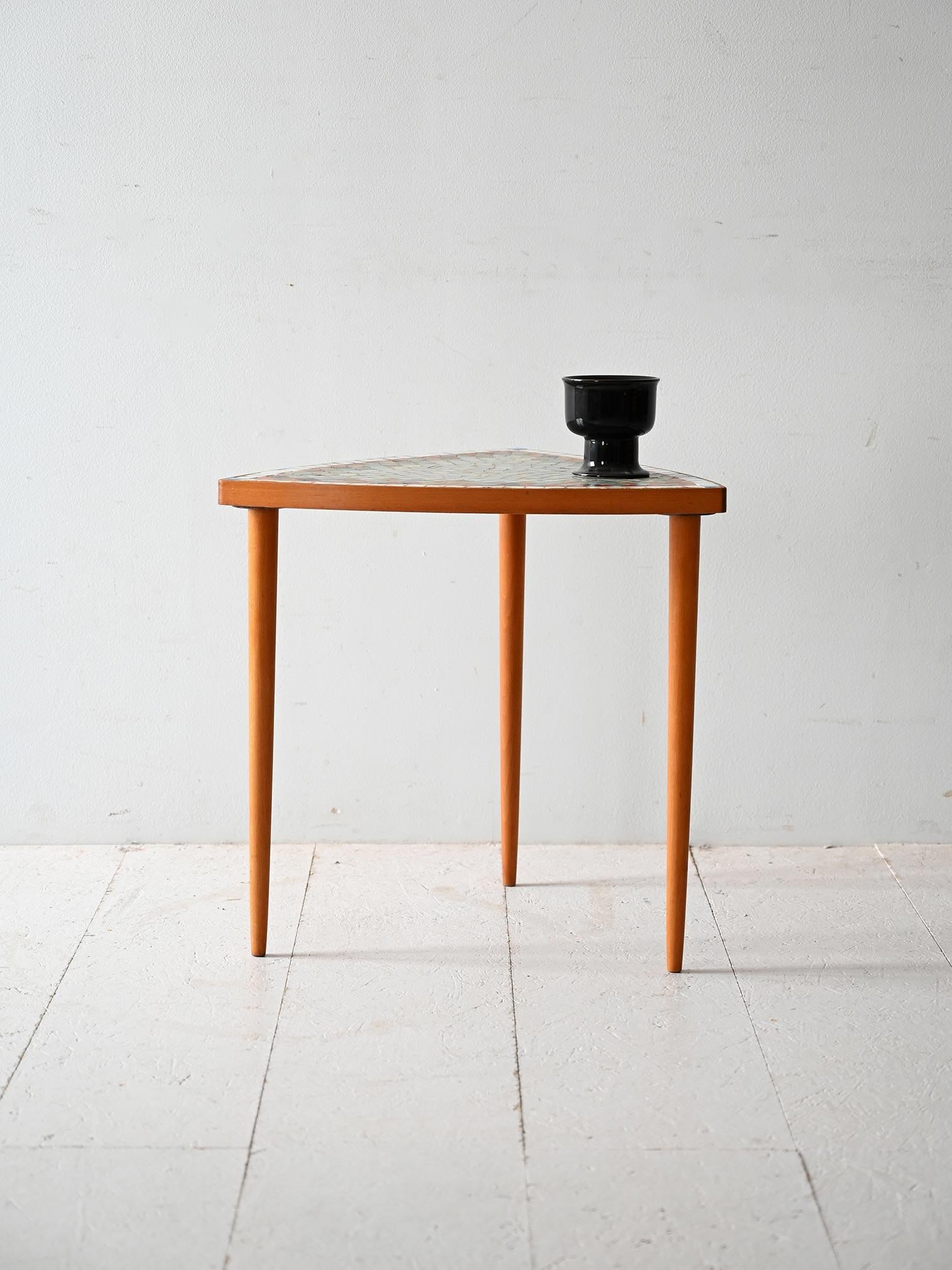 Scandinavian coffee table from the 1960s with mosaic-decorated triangular top, made by EJM, with original label under the top.

Elegant Scandinavian coffee table made in the 1960s by manufacturer EJM. The triangular top is decorated with a
