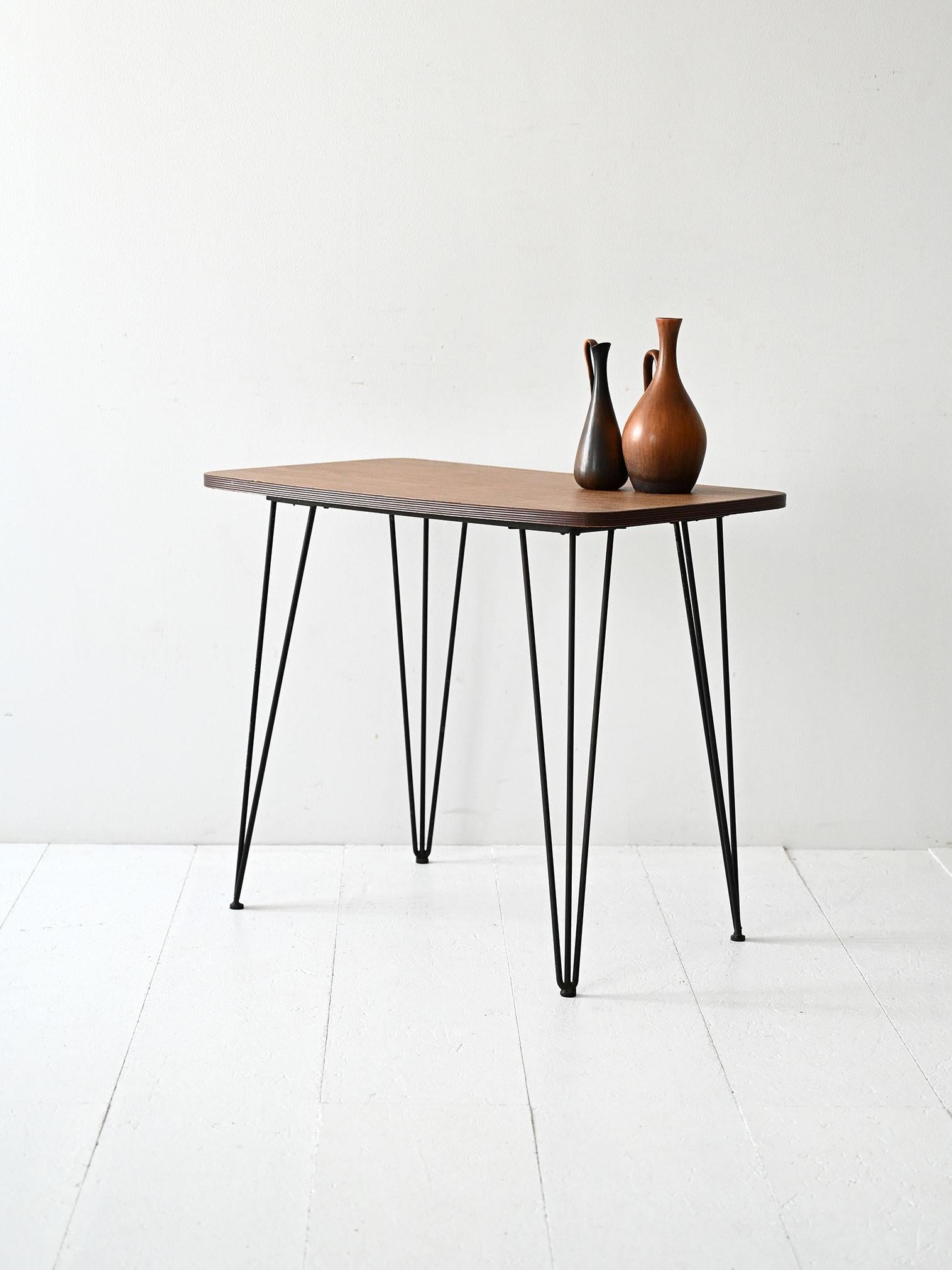 Scandinavian 1950s coffee table with formica top and black metal frame with thin tapered legs.

Clean lines and well-balanced proportions for a vintage Scandinavian coffee table from the 1950s. The formica-covered plywood top shows visible signs of