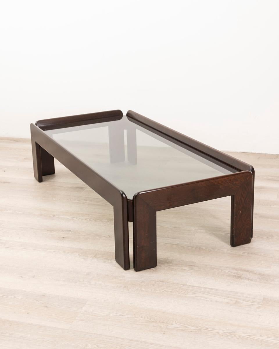 Coffee table in polished Walnut wood and smoked glass top, design Afra & Tobia scarpa, 1970s.

CONDITION: In good condition, may show signs of wear given by time.

DIMENSIONS: Height 35 cm; Width 134 cm; Length 63 cm

MATERIALS: Wood and Glass

YEAR