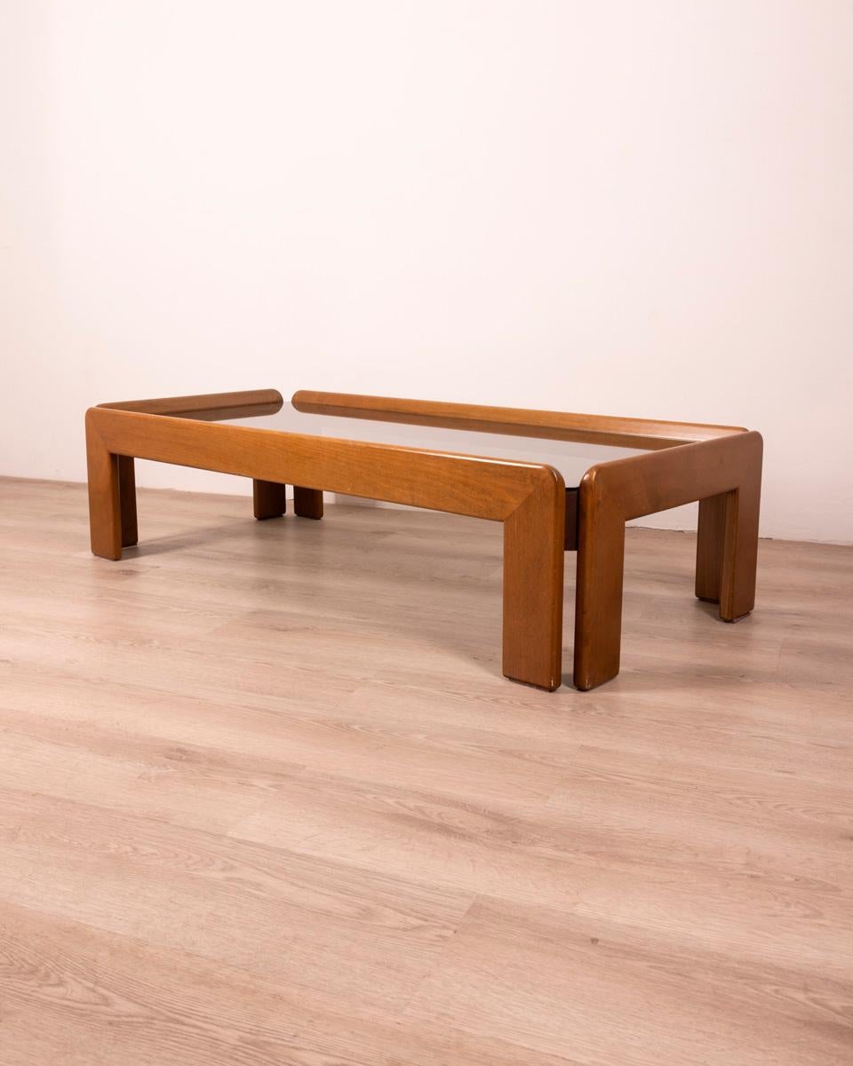 Coffee table in polished Walnut wood and smoked glass top, design Afra & Tobia Scarpa, 1970s.

CONDITION: In good condition, may show signs of wear given by time.

DIMENSIONS: Height 35 cm; Width 134 cm; Length 63 cm

MATERIALS: Wood and Glass

YEAR