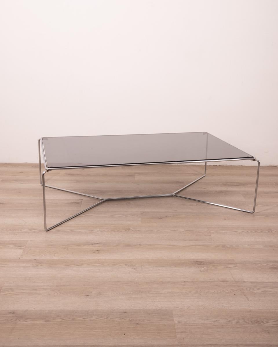 Tavolino con struttura in metallo cromato e piano in vetro fumè.
Modello Marcel 470, design Kazuhide Takahama per Simon Cassina, anni 70.

CONDIZIONI: In buone condizioni, può presentare segni d'usura dati dal tempo, il vetro ha una sbeccattura