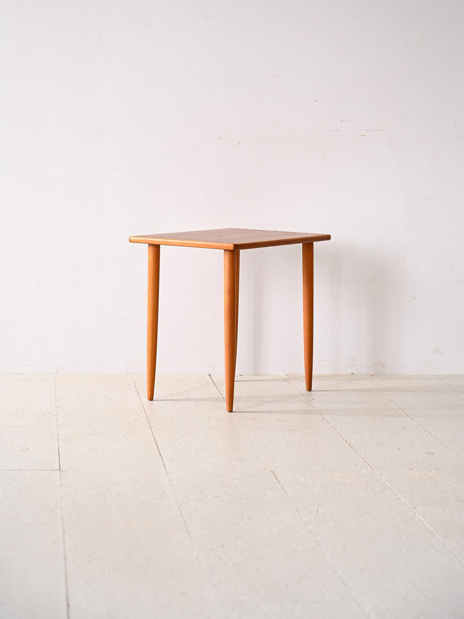 Couchtisch aus nordischer Produktion aus den 1960er Jahren.

Ein schlichtes und elegantes Möbelstück, das gut in verschiedene Kontexte und Stile passt. Bestehend aus einer rechteckigen Teakholzplatte und langen, konischen Beinen, die die Figur