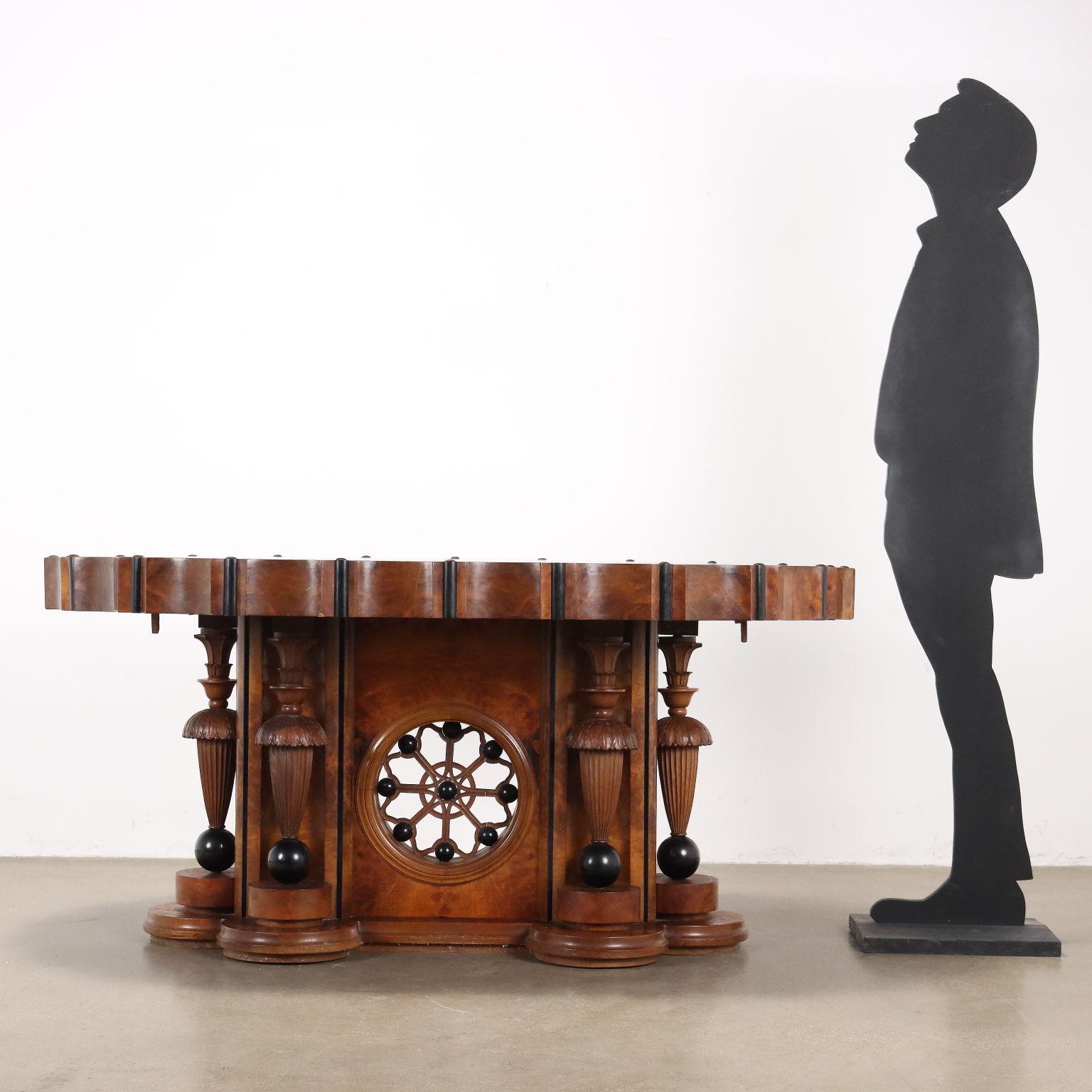 Tavolo Art Déco inizi '900. Di forma ovale il piano è lavorato a spicchi in tutta la sua circonferenza, con l'inserto di cilindri ebanizzati, la gamba  centrale di sostegno è realizzata da un grande pannello con al centro una ruota traforata con